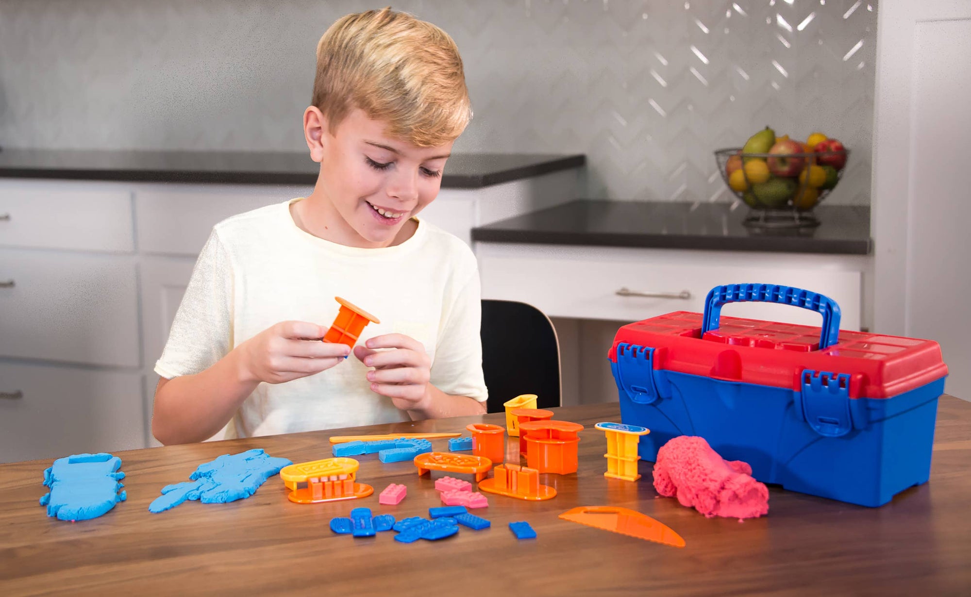 Child playing with a toy set on a table in a kitchen