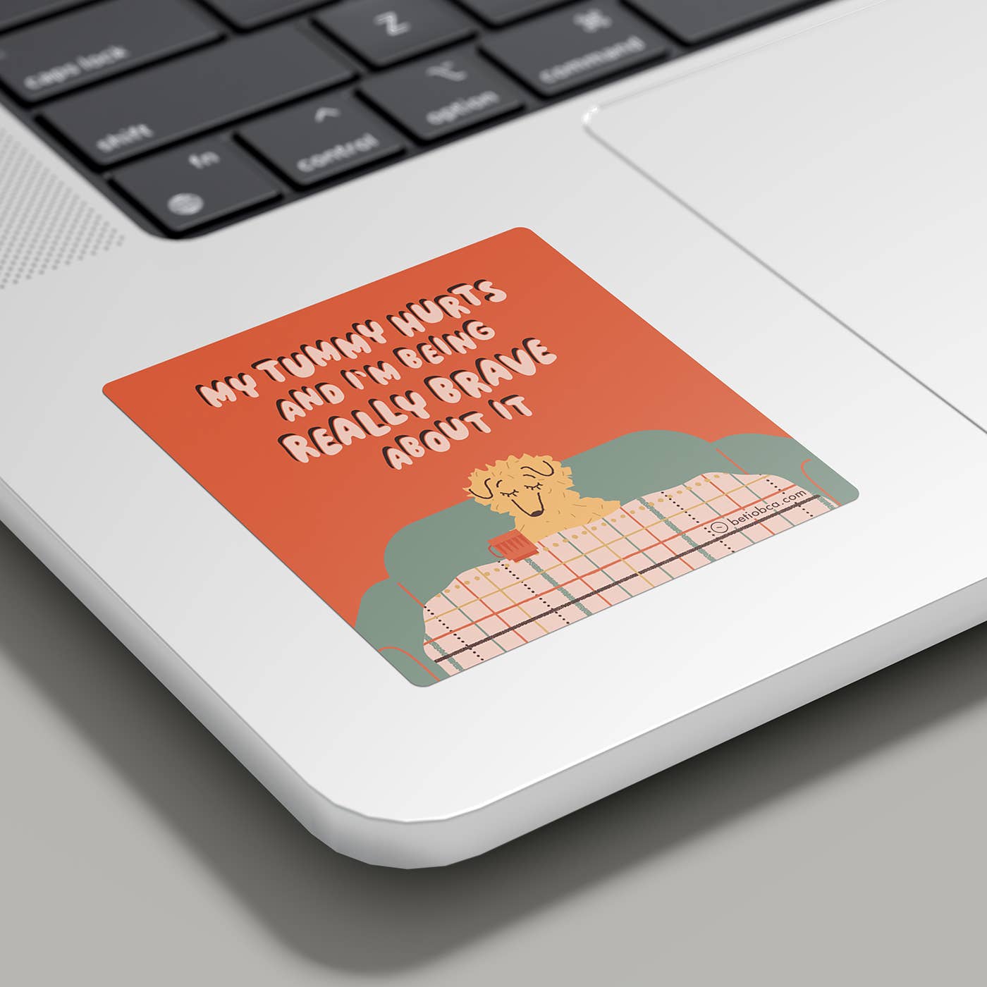 Laptop with a sticker on the palm rest area featuring text and an illustration.