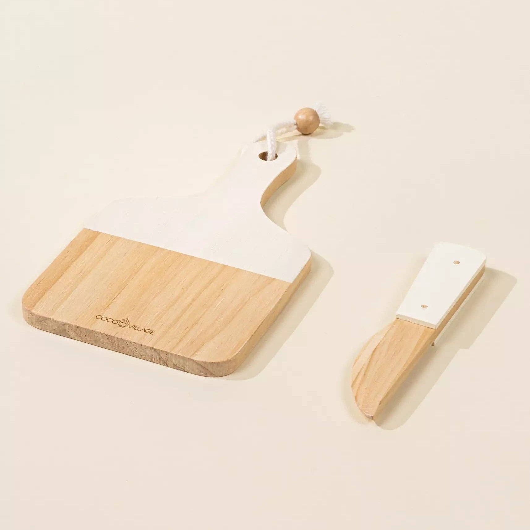 Wooden cutting board with knife and brush on a beige background