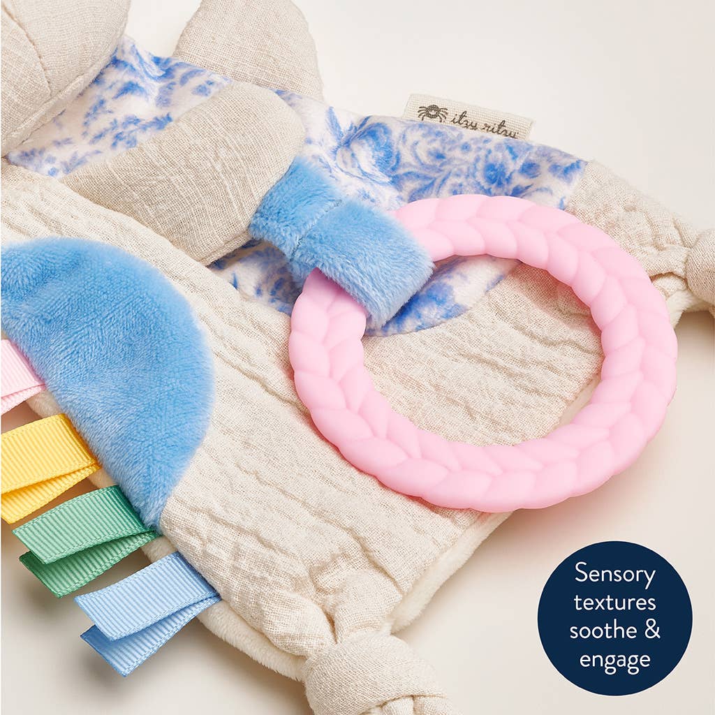 Baby toy with textured elements and a pink ring on a soft background