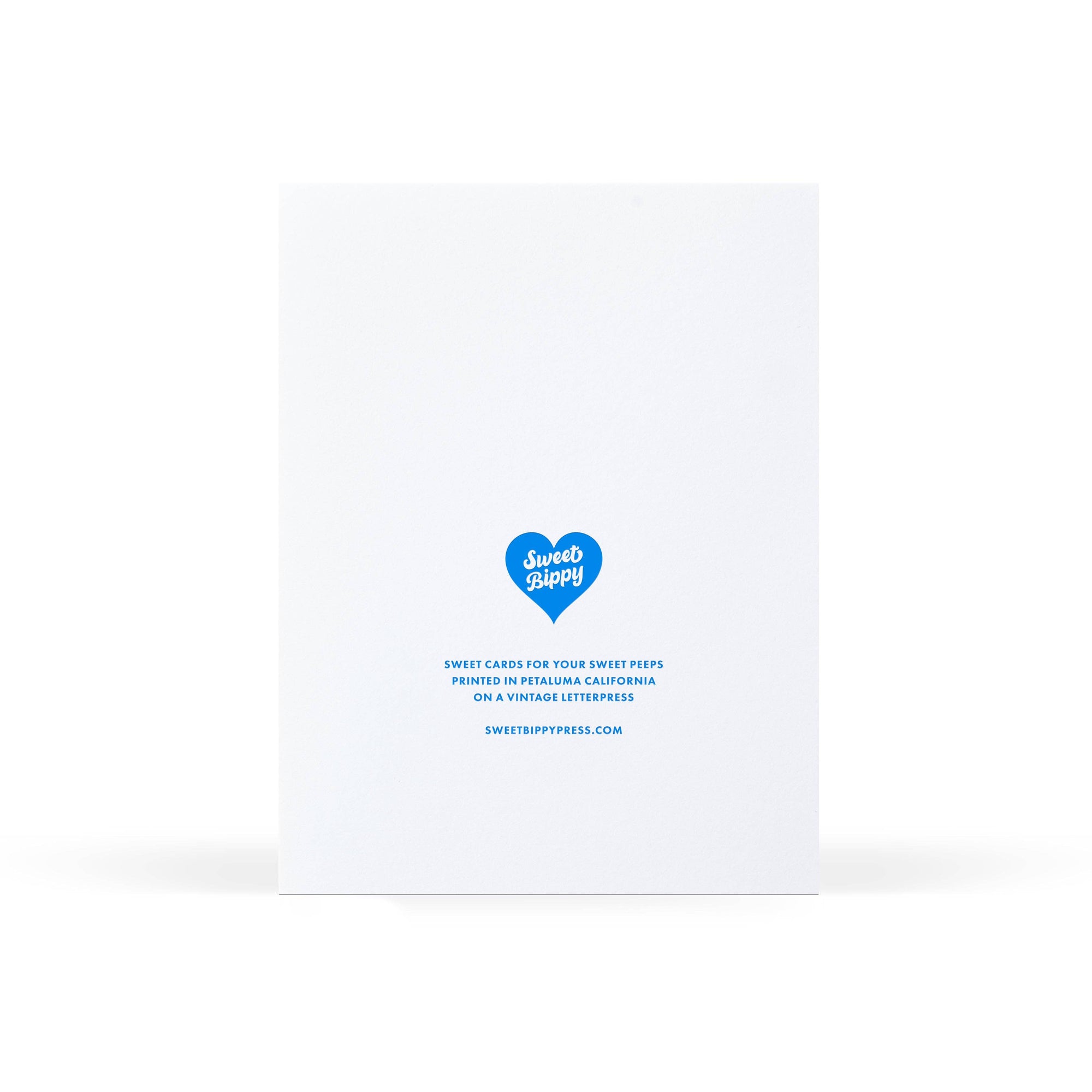 A white greeting card standing upright on a white background, with blue text and a blue heart-shaped logo reading 'Sweet Cards' near the lower center.