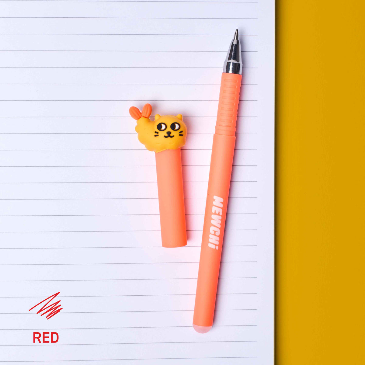 Two orange pens with cat-shaped clips on lined paper
