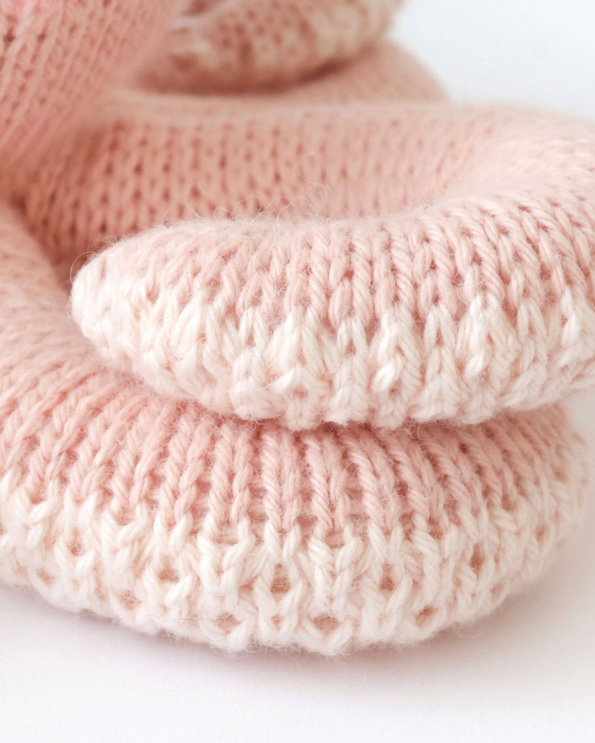 Stack of pink knitted fabrics on a white background