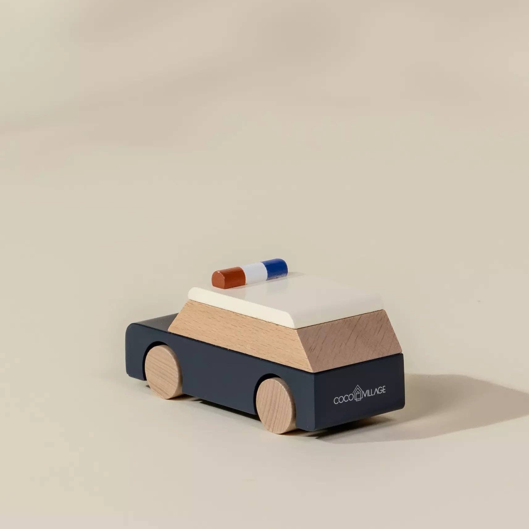 Wooden toy car with a police light on a beige background