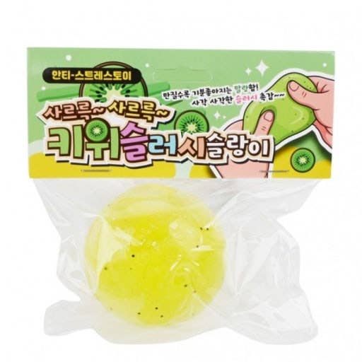 A packaged yellow squishy toy with a green kiwi-themed header card. The clear plastic bag contains a translucent yellow foam-like ball with small black specks, and the top card shows kiwi graphics and a hand stretching the toy.