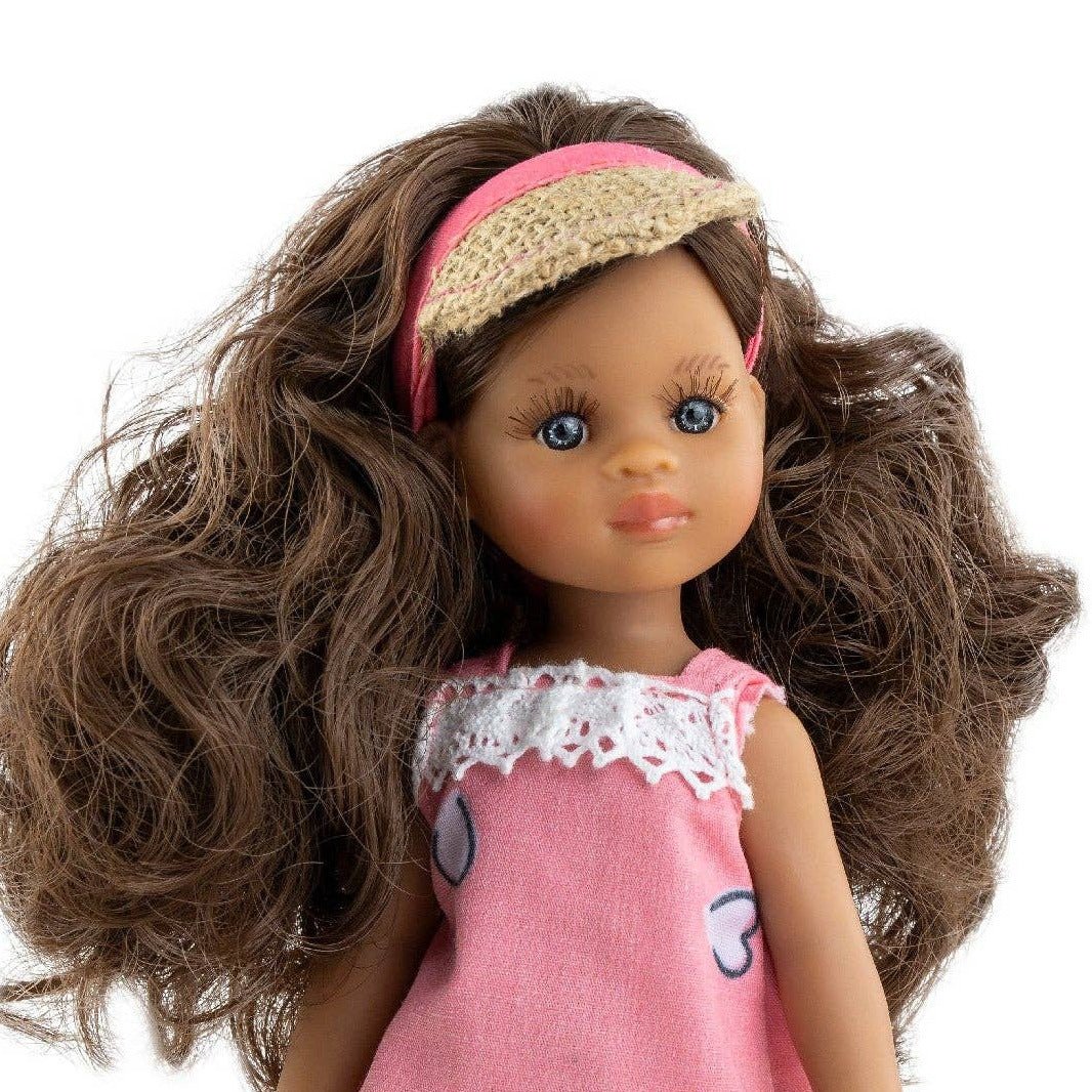 Doll wearing a pink outfit with heart patterns on a white background