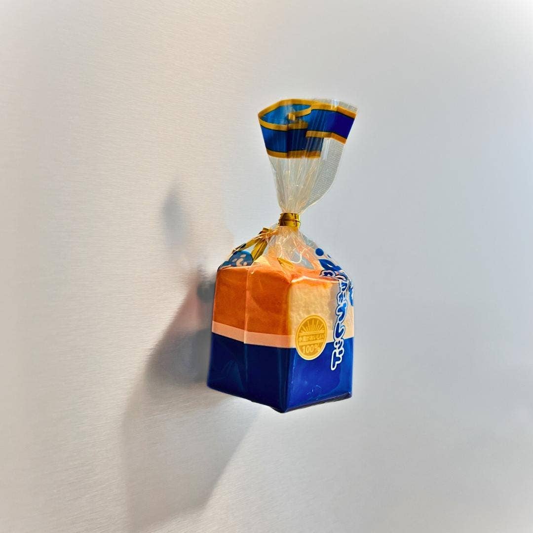 Cube-shaped product with blue and orange packaging on a light gray background