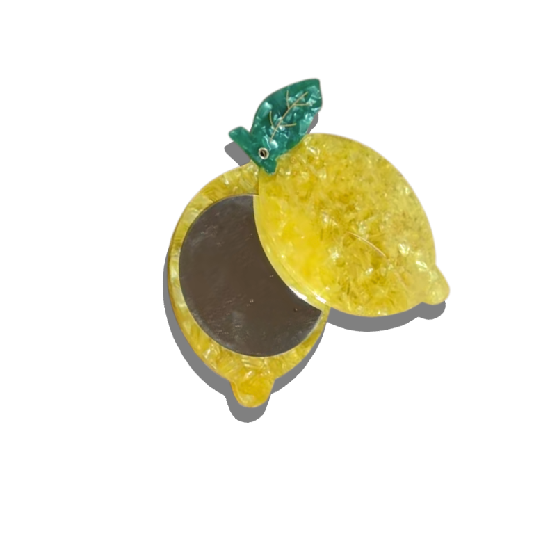 Compact mirror shaped like a lemon with a green leaf on a white background