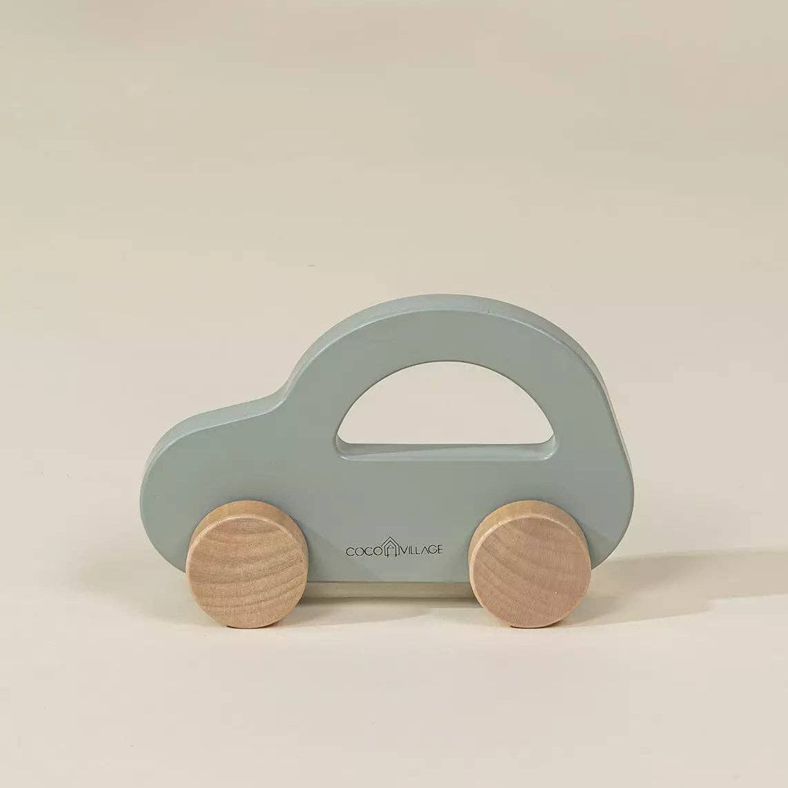 Toy car with wooden wheels on a beige background