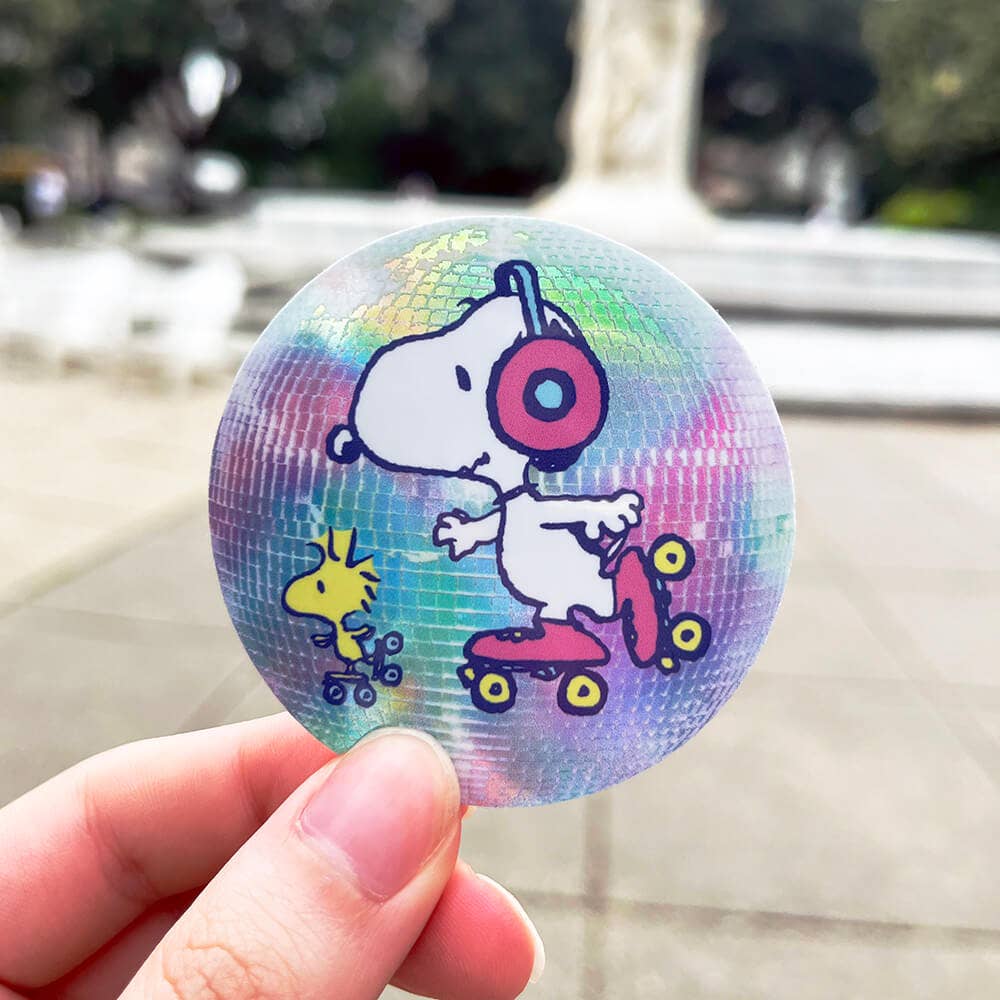 Holographic sticker with cartoon character on a blurred outdoor background