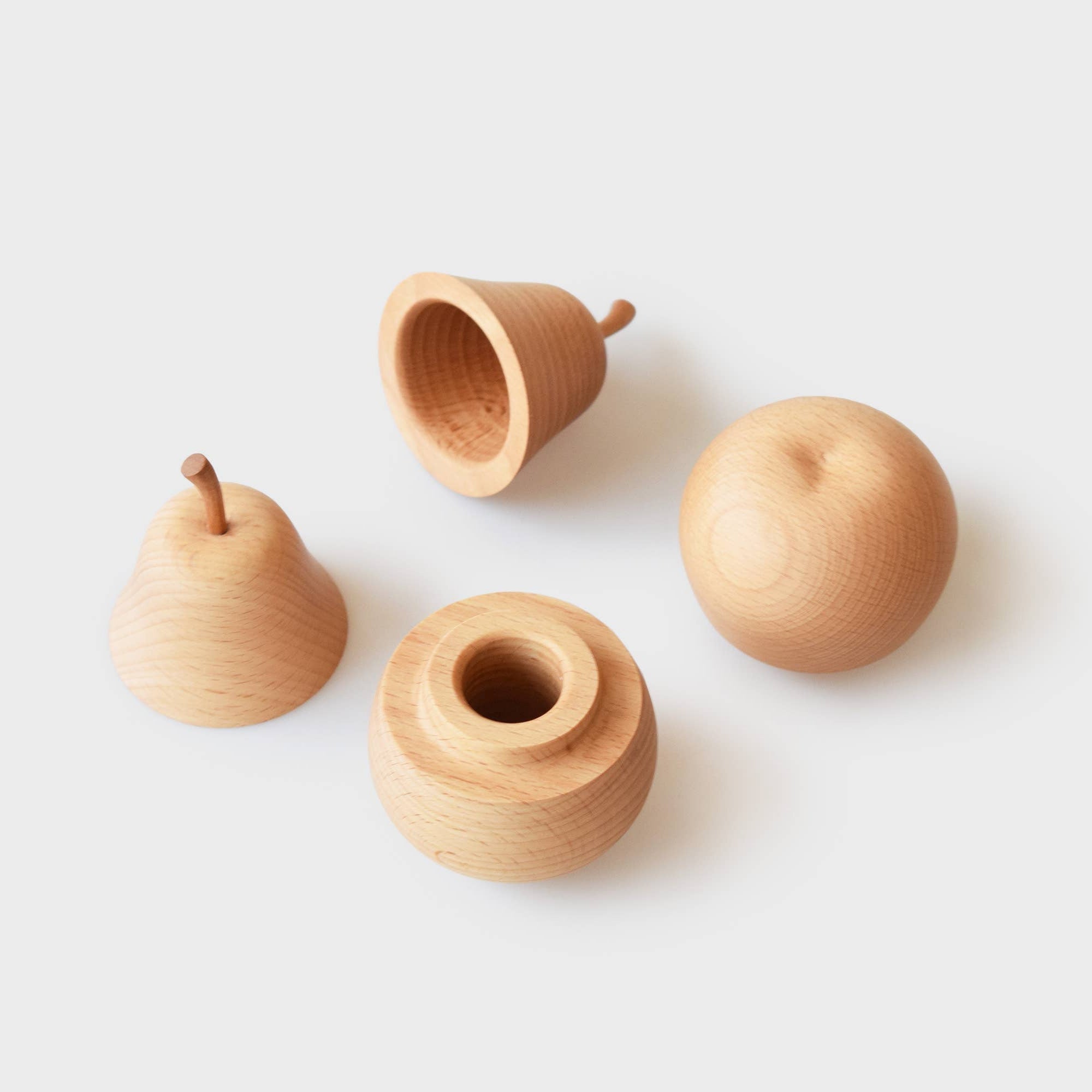 Set of four wooden pear holders on a white background