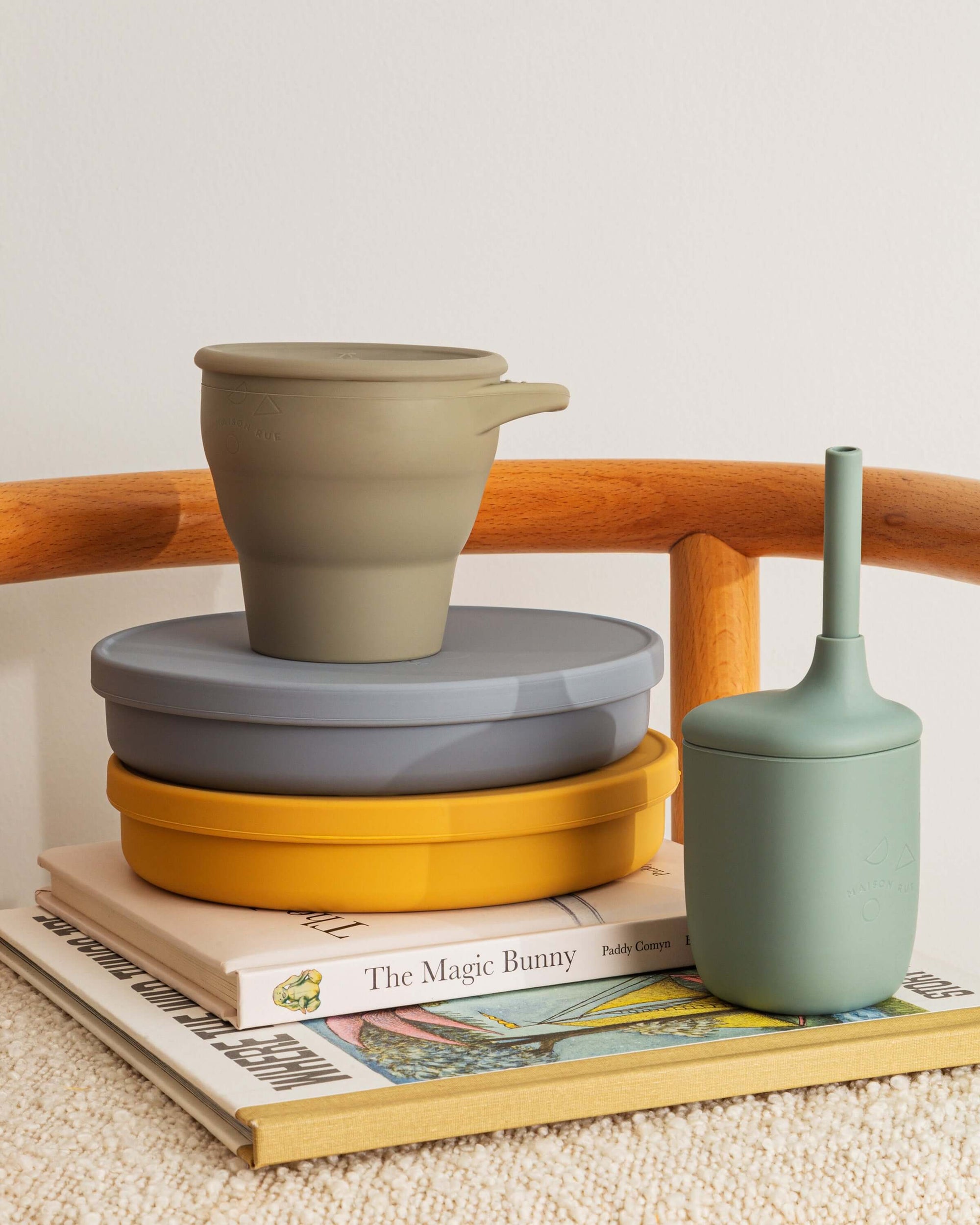 Set of silicone containers on a wooden surface with a book underneath