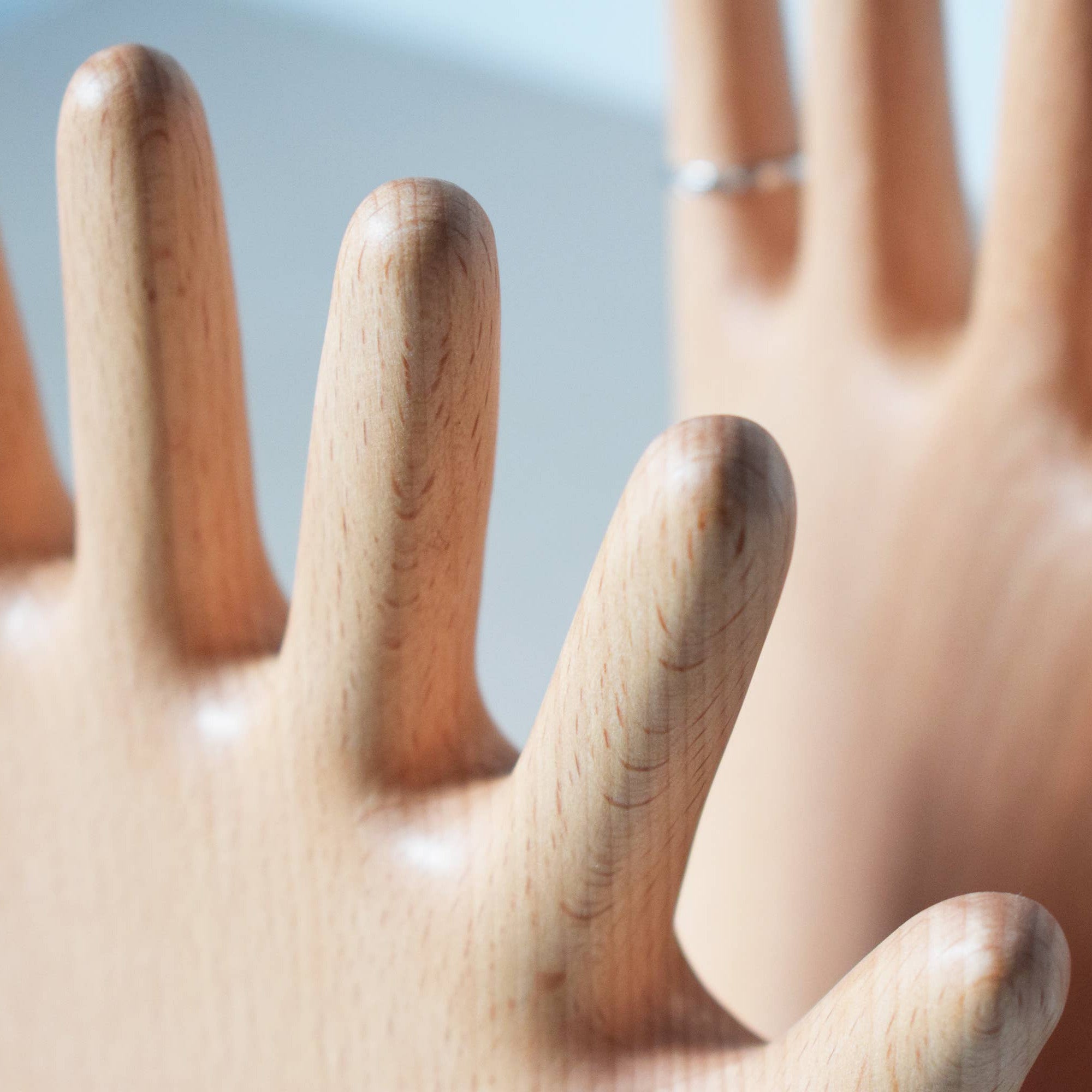 Wooden hand-shaped comb with a blurred background