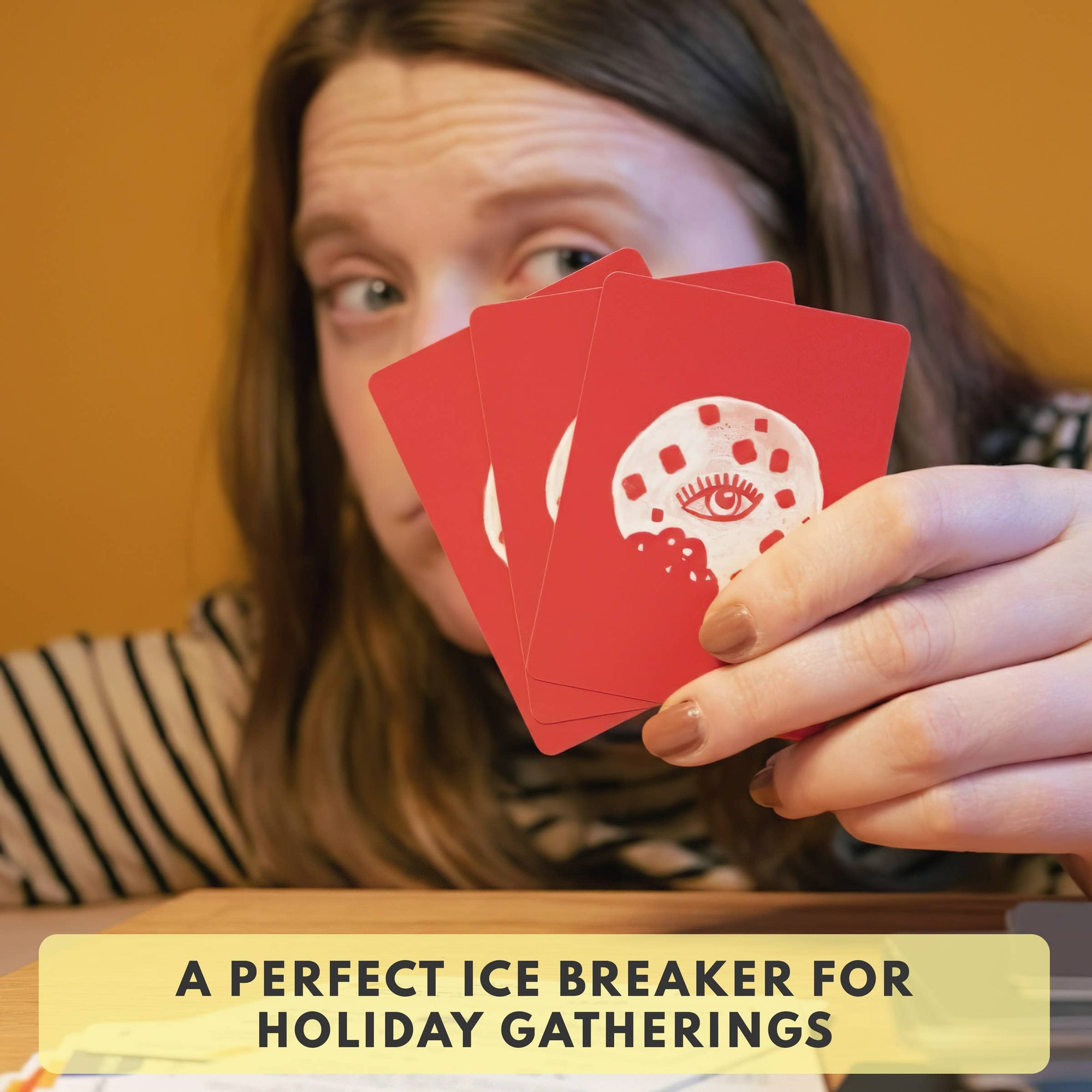 Person holding red cards with a snowman design, text 'A PERFECT ICE BREAKER FOR HOLIDAY GATHERINGS' below.