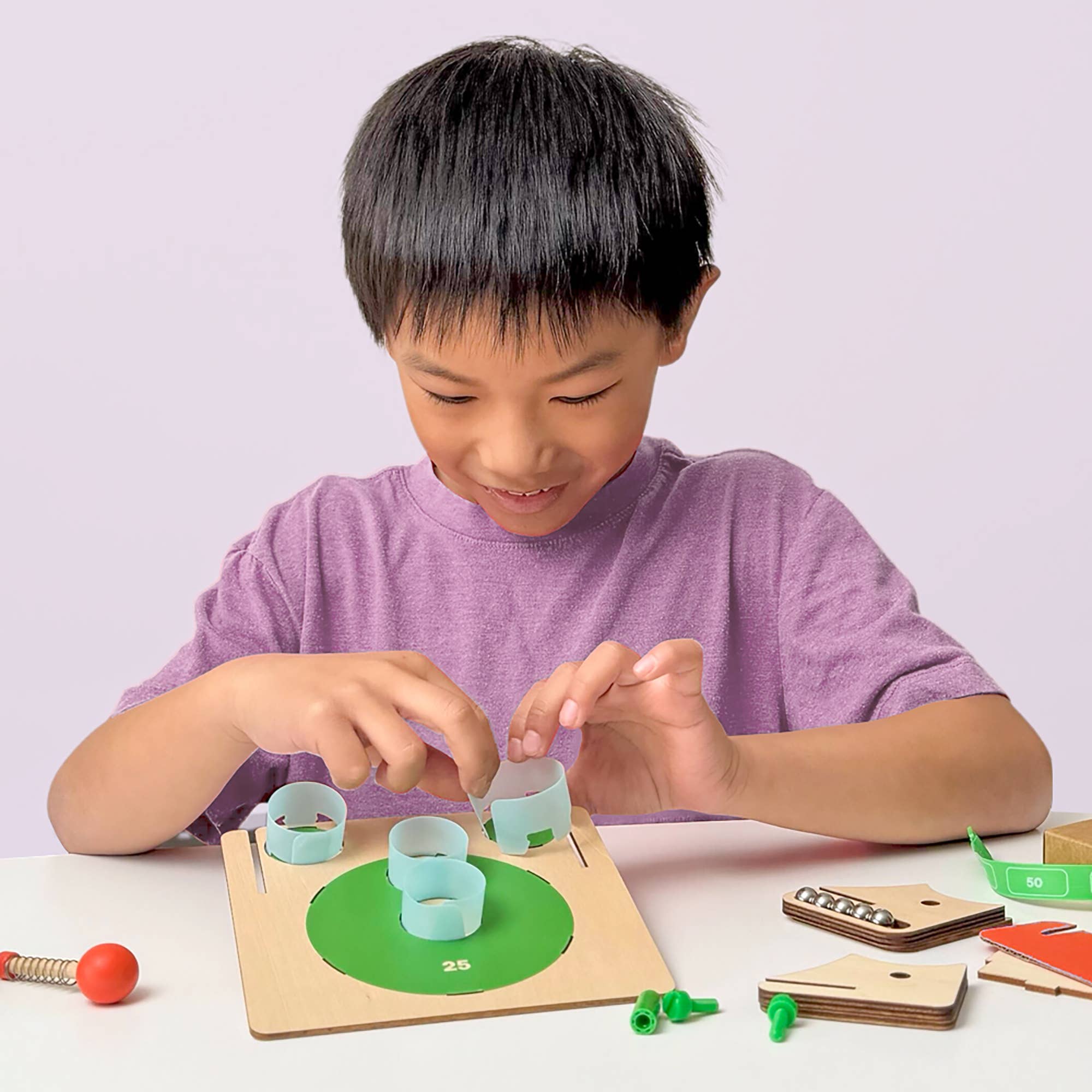 Child playing with a wooden educational toy on a white surface