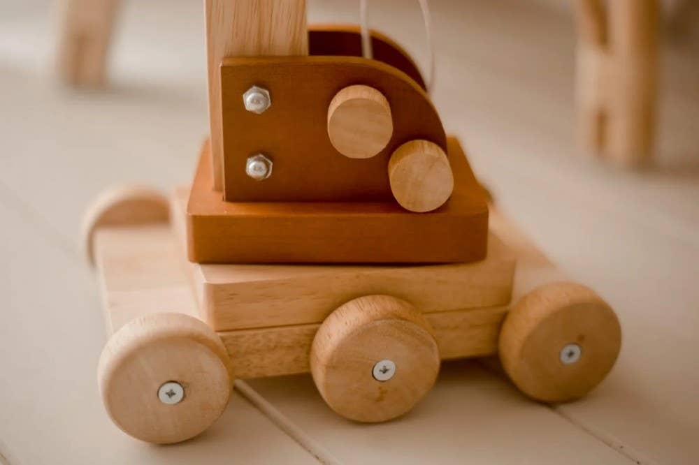 Wooden toy with wheels on a light wooden floor