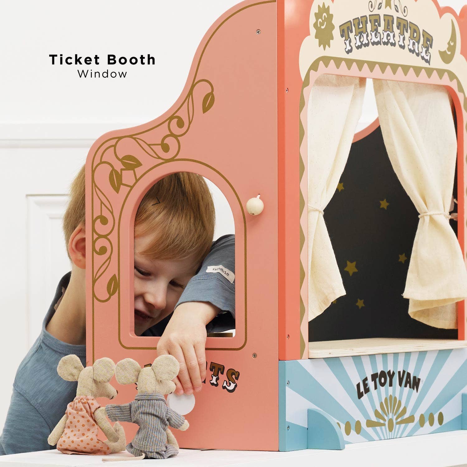 Child playing with a Le Toy Van puppet theatre set.