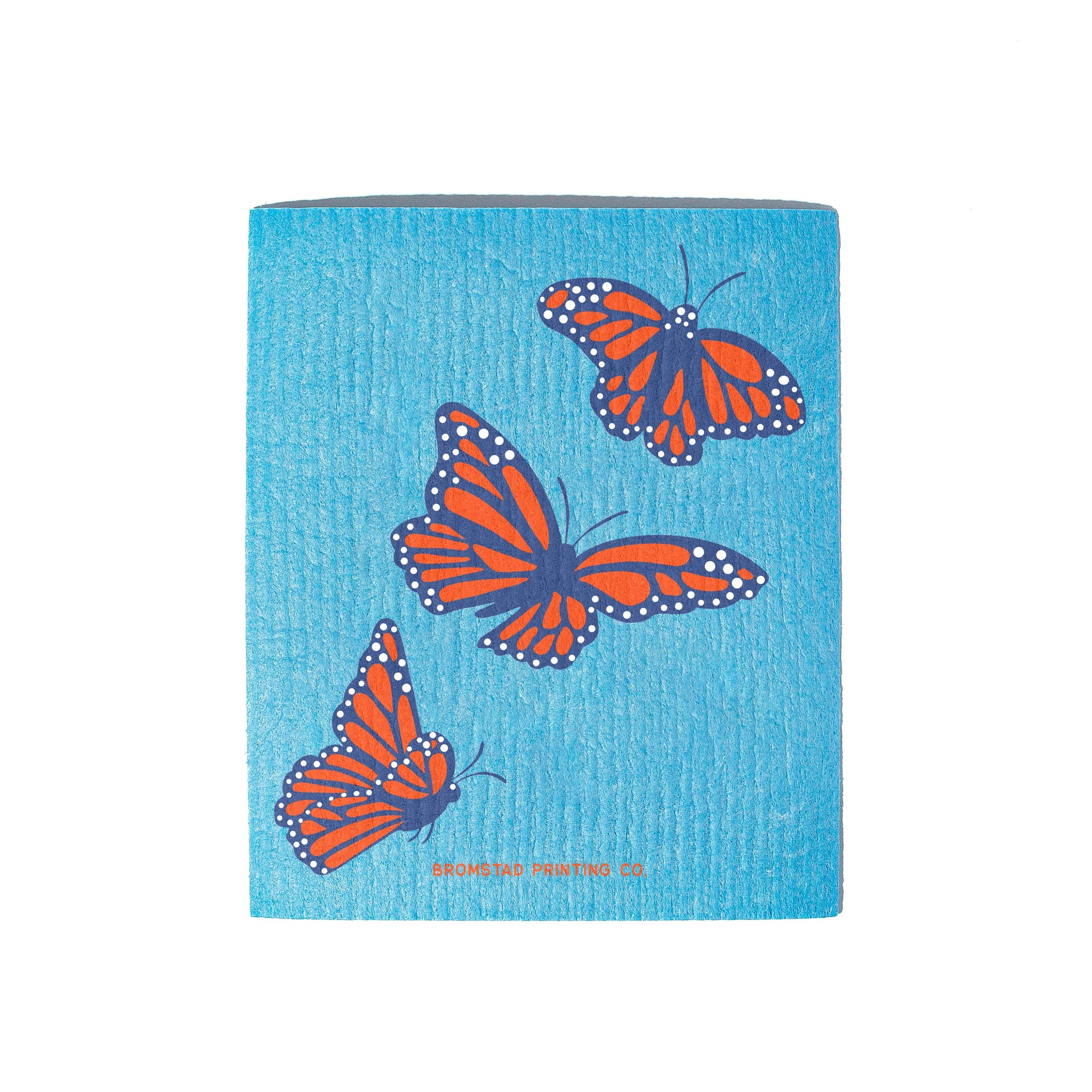 A square blue textured paper napkin featuring three orange and blue monarch butterflies, with the brand name 'BROOKFIELD PRINTING CO.' printed in small orange text at the bottom.