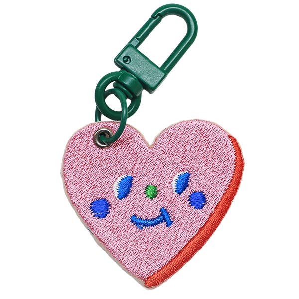 Heart-shaped keychain with a smiley face design on a white background