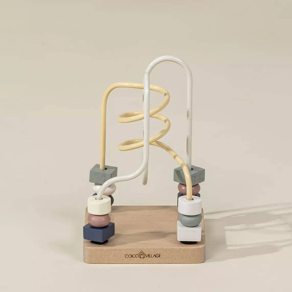 Colorful wooden toy with beads and coiled wires on a beige background