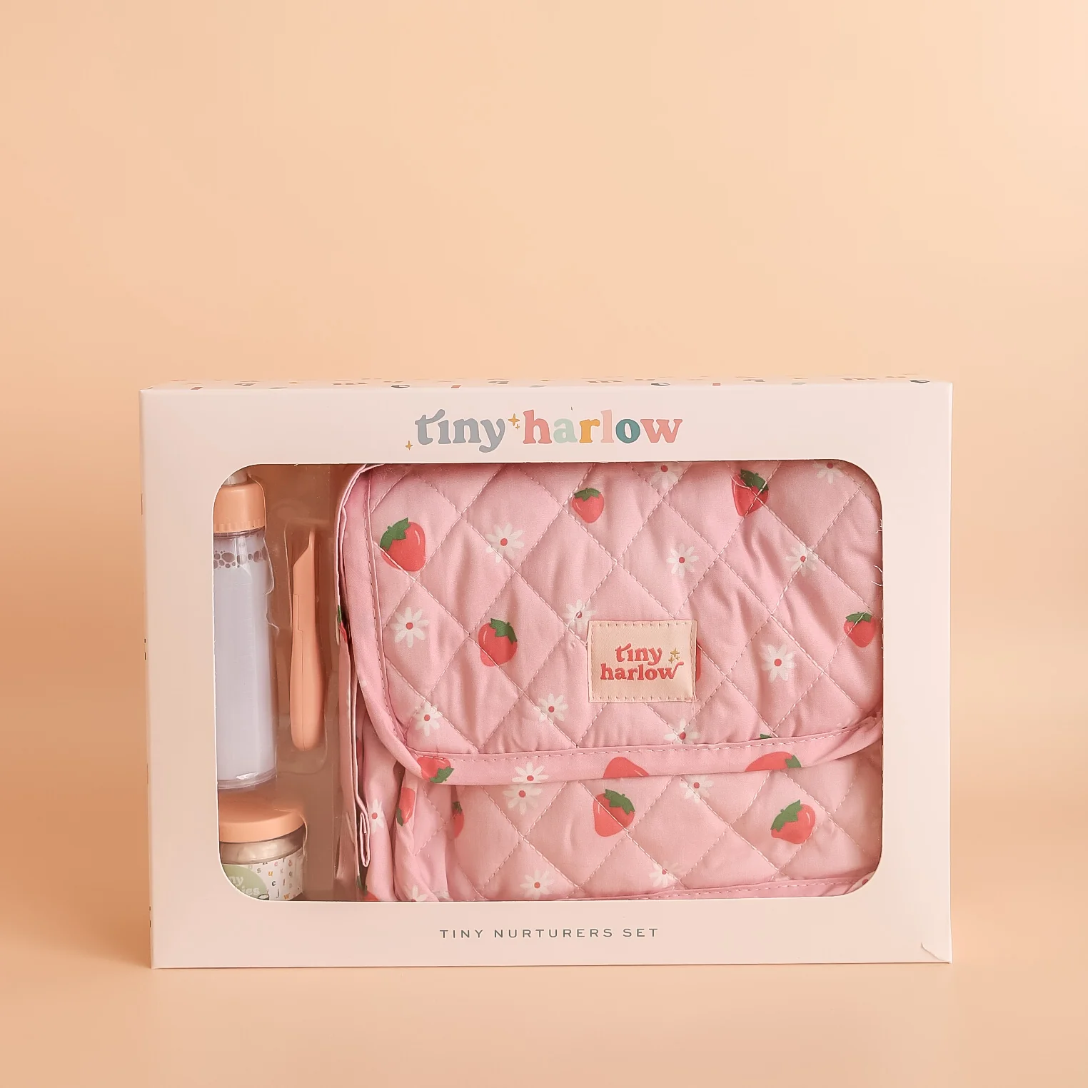 Tiny Harlow baby doll feeding  set in packaging on a beige background