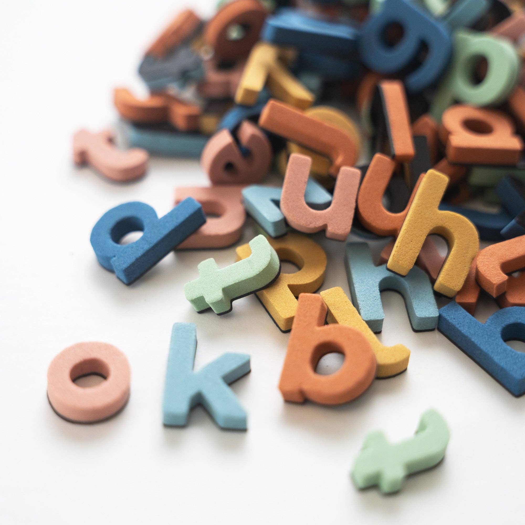 Colorful wooden letters scattered on a white background