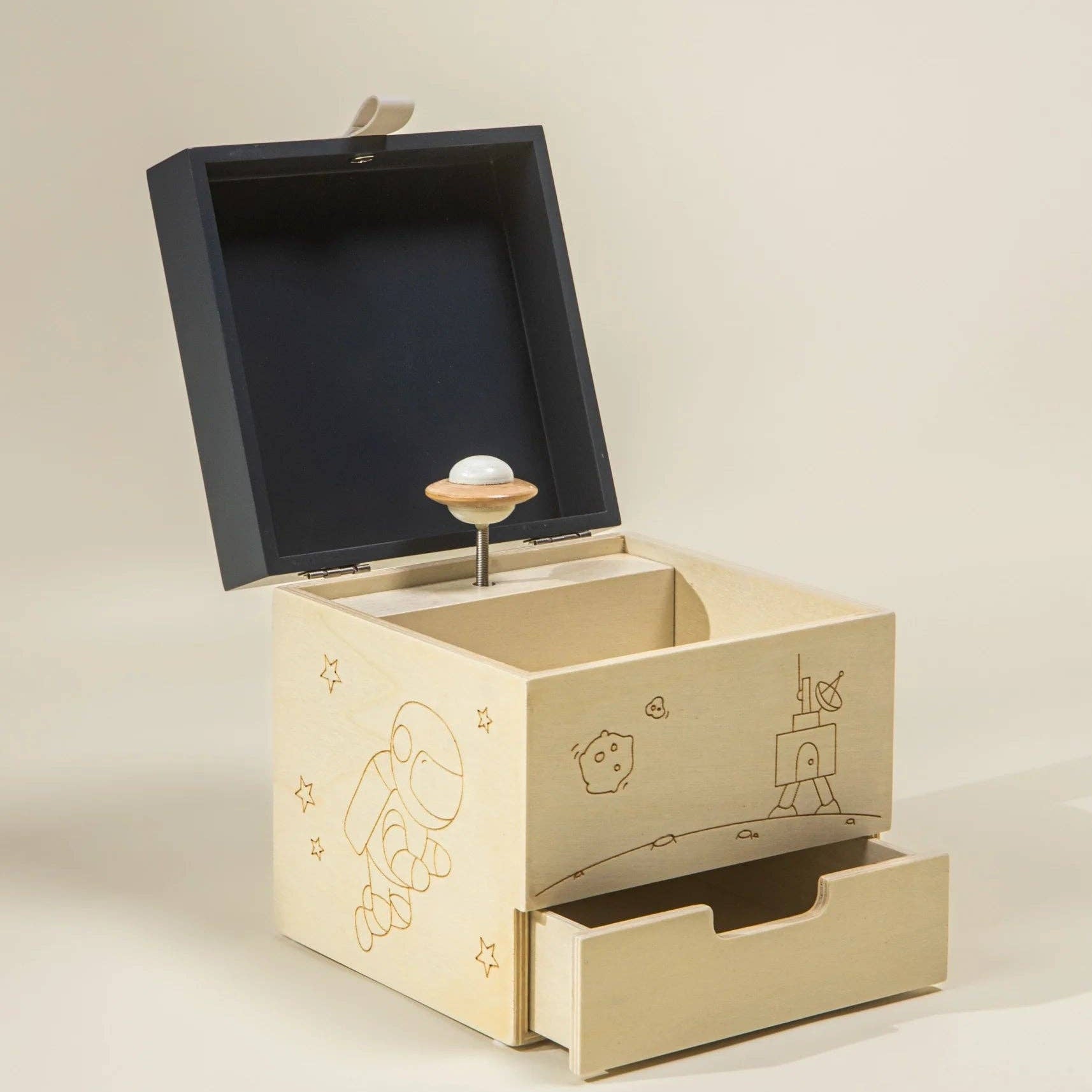 Wooden music box with open lid on a beige background