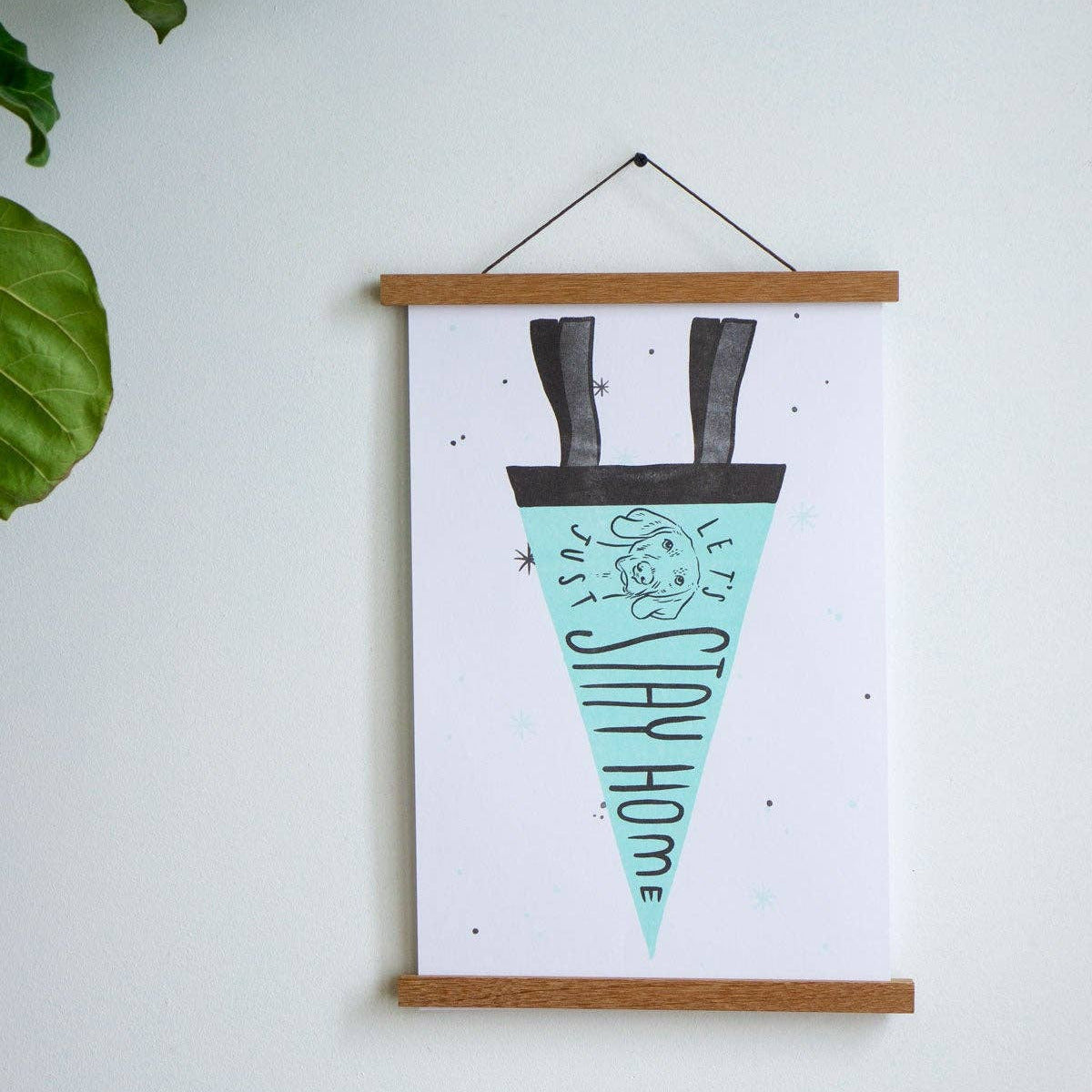 Framed artwork with a design of a hat and text on a white wall.