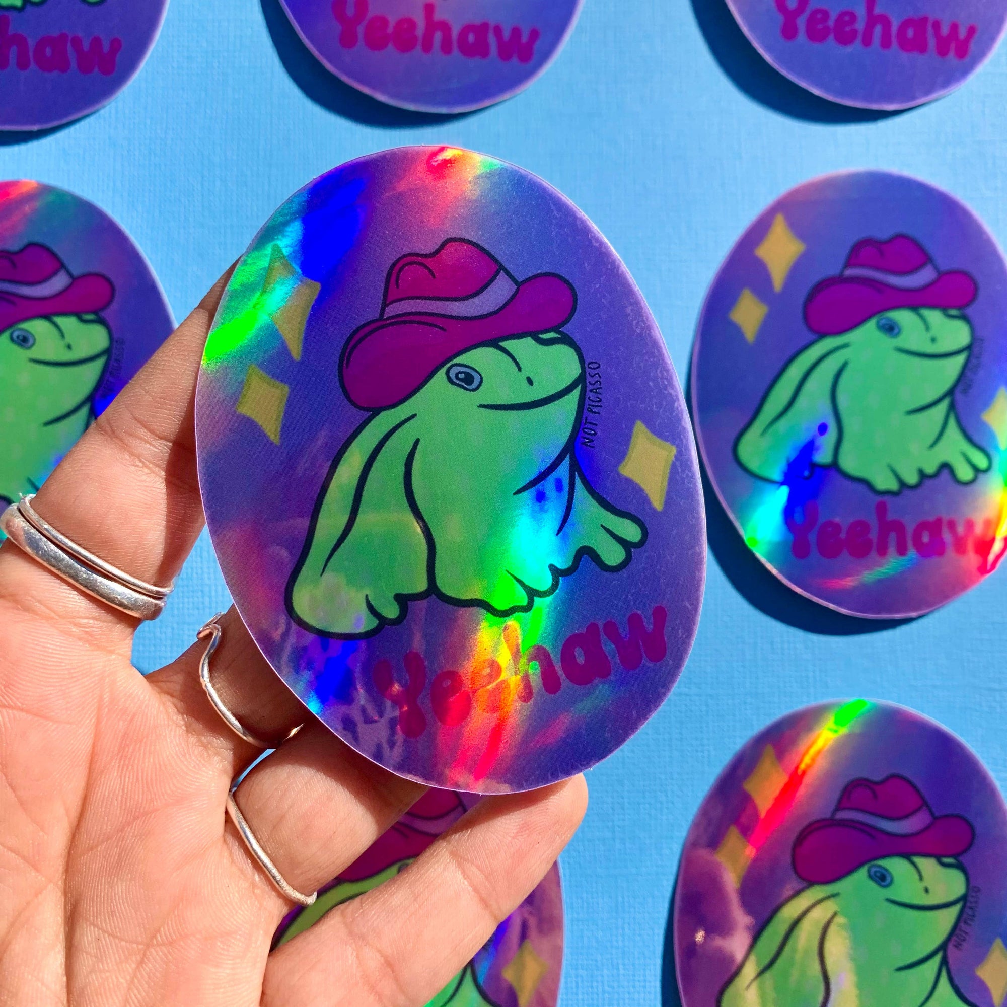 Holographic buttons with a frog design and 'Yeehaw' text on a blue background.