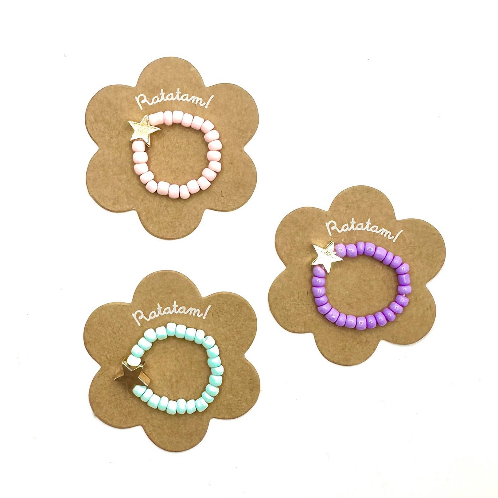 Three beaded bracelets on flower-shaped cards with 'Ratatam!' text on a white background