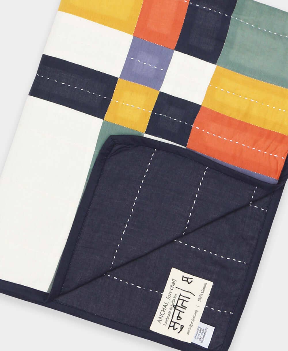 Colorful quilt with a visible brand label on a white background