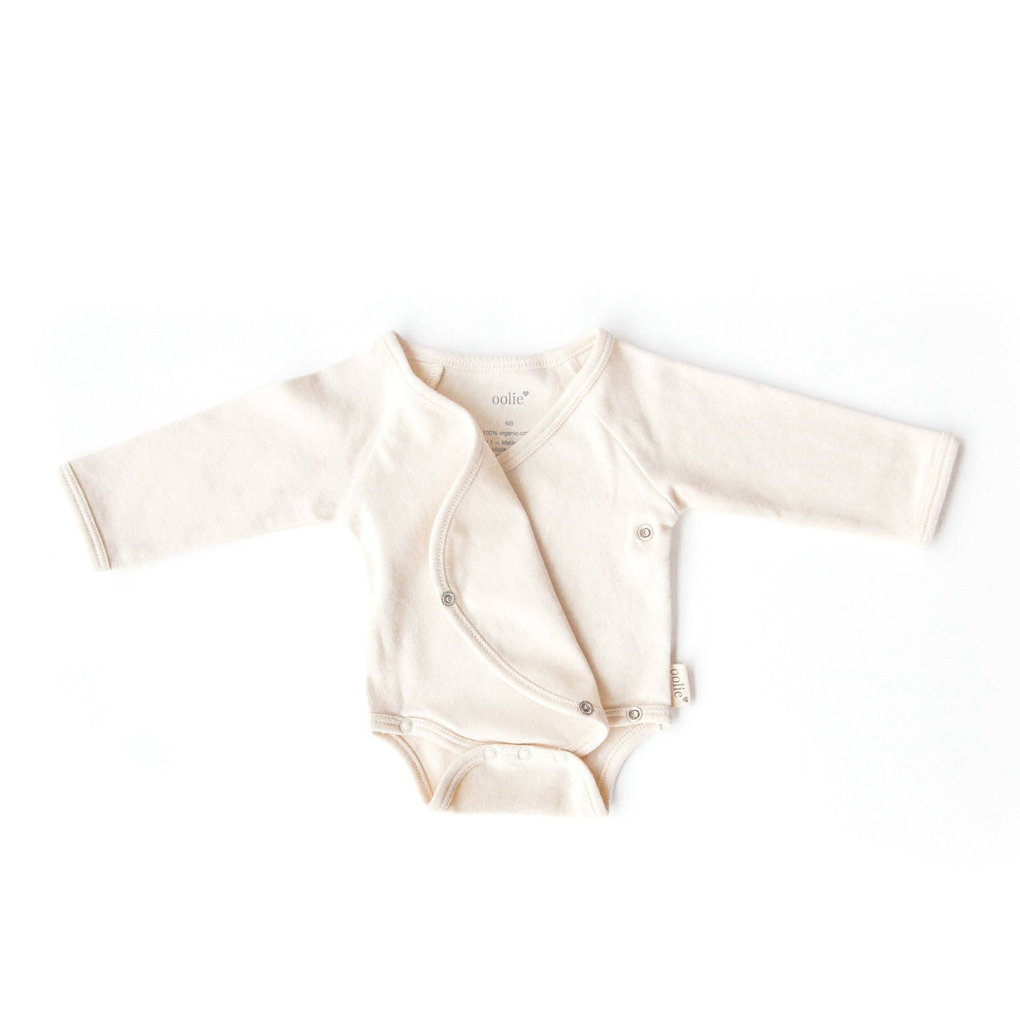 Beige baby onesie with long sleeves on a white background
