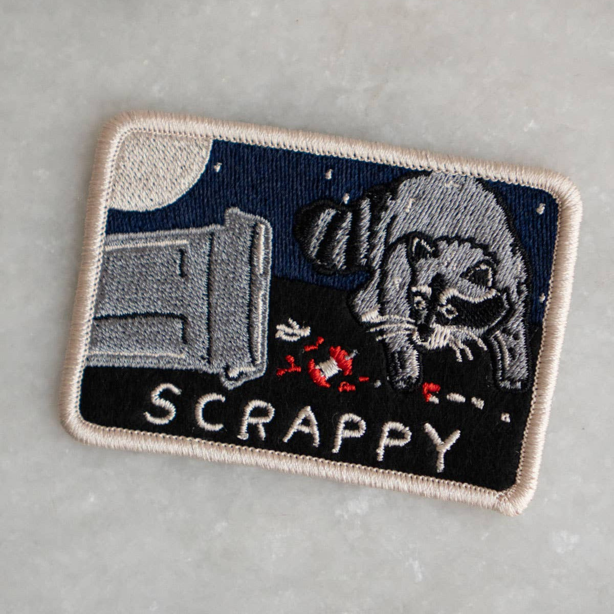 Embroidered patch with a dog and TV design on a gray background