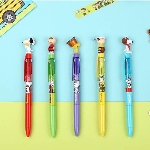 Set of colorful pens with cartoon character designs on a blue and yellow background