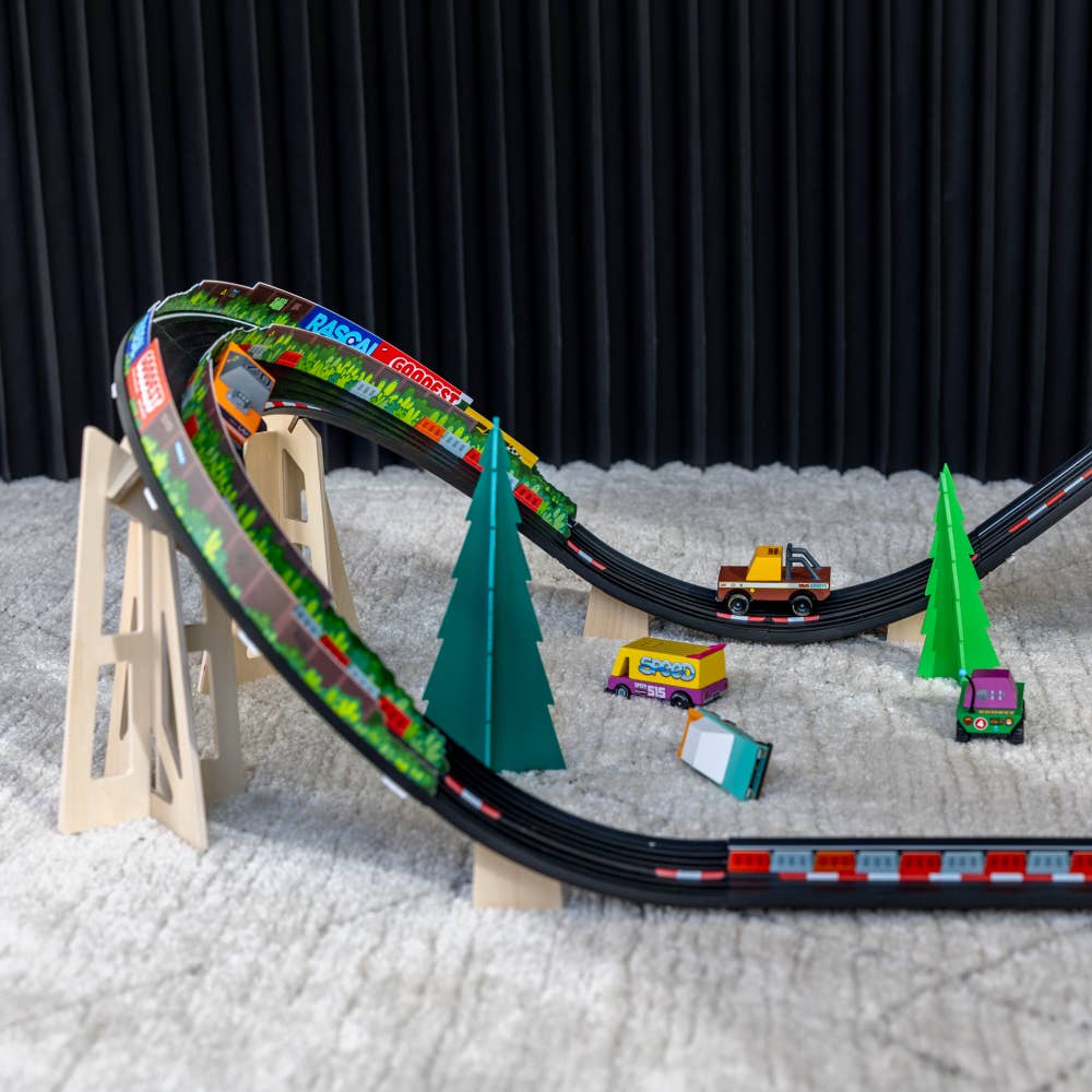 Toy train track set with trains and trees on a textured surface