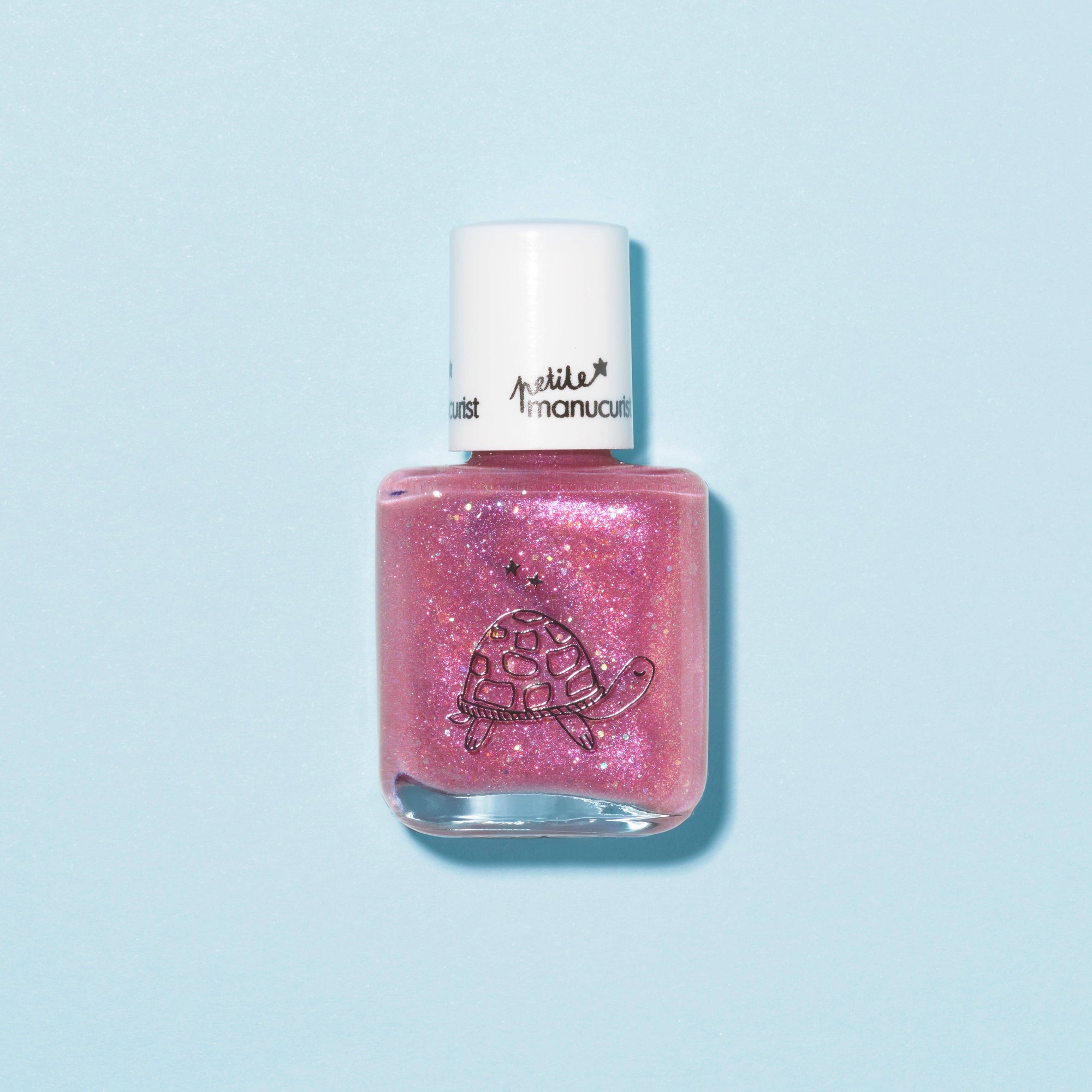Pink glittery nail polish bottle with a white cap on a light blue background