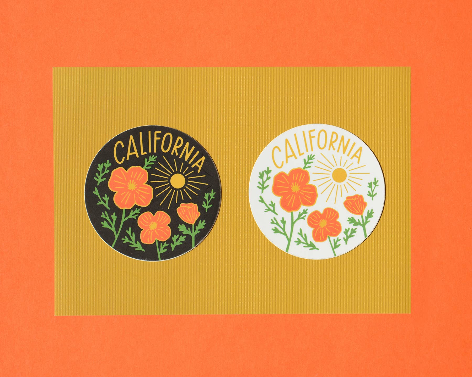 Two 'California' themed stickers with floral designs on a textured orange background.