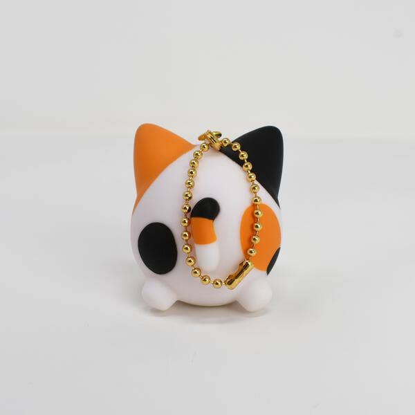 Cat-shaped keychain with orange, black, and white colors on a light gray background