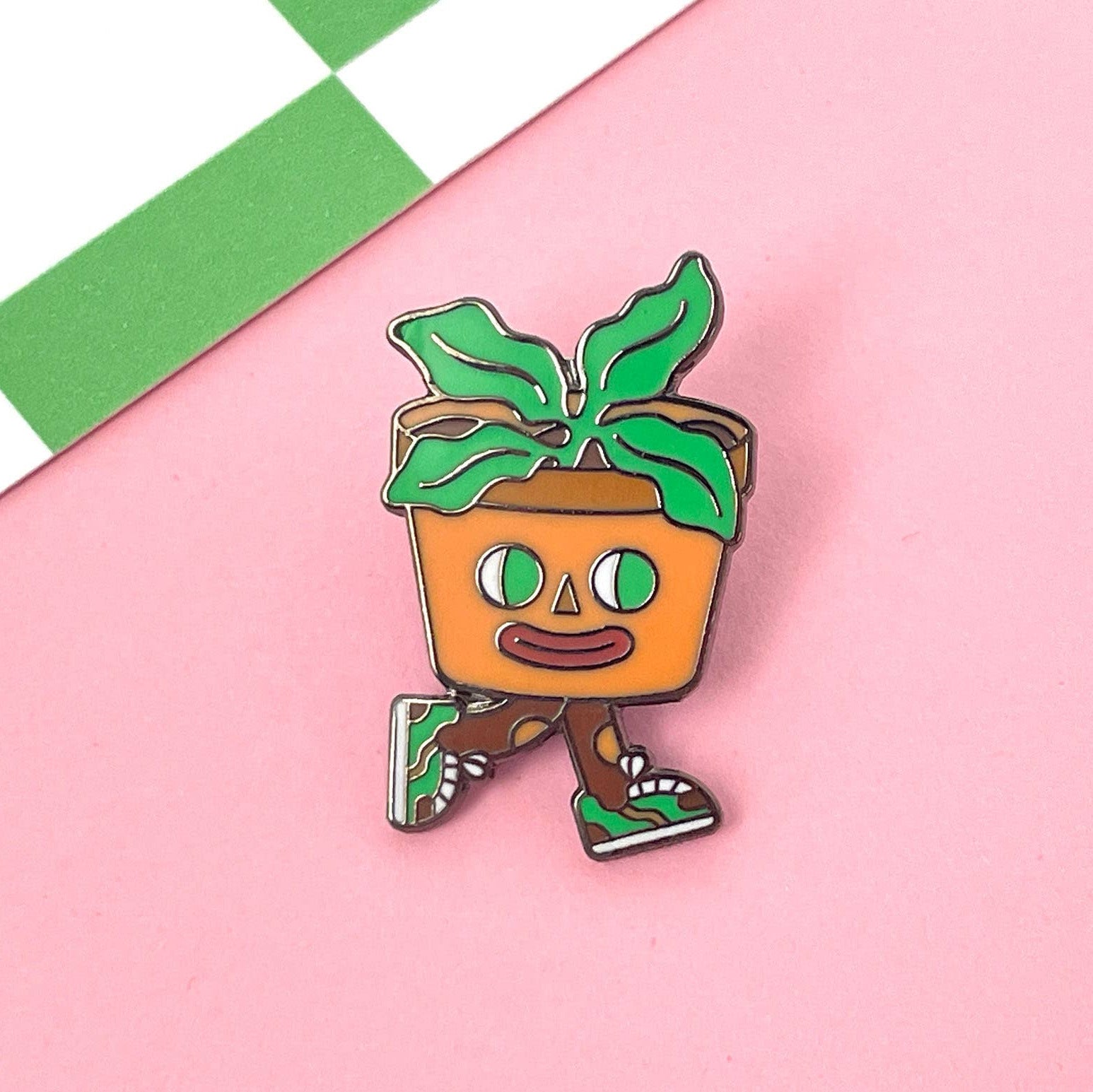 Cartoon-style potted plant character on a pink and green checkered background