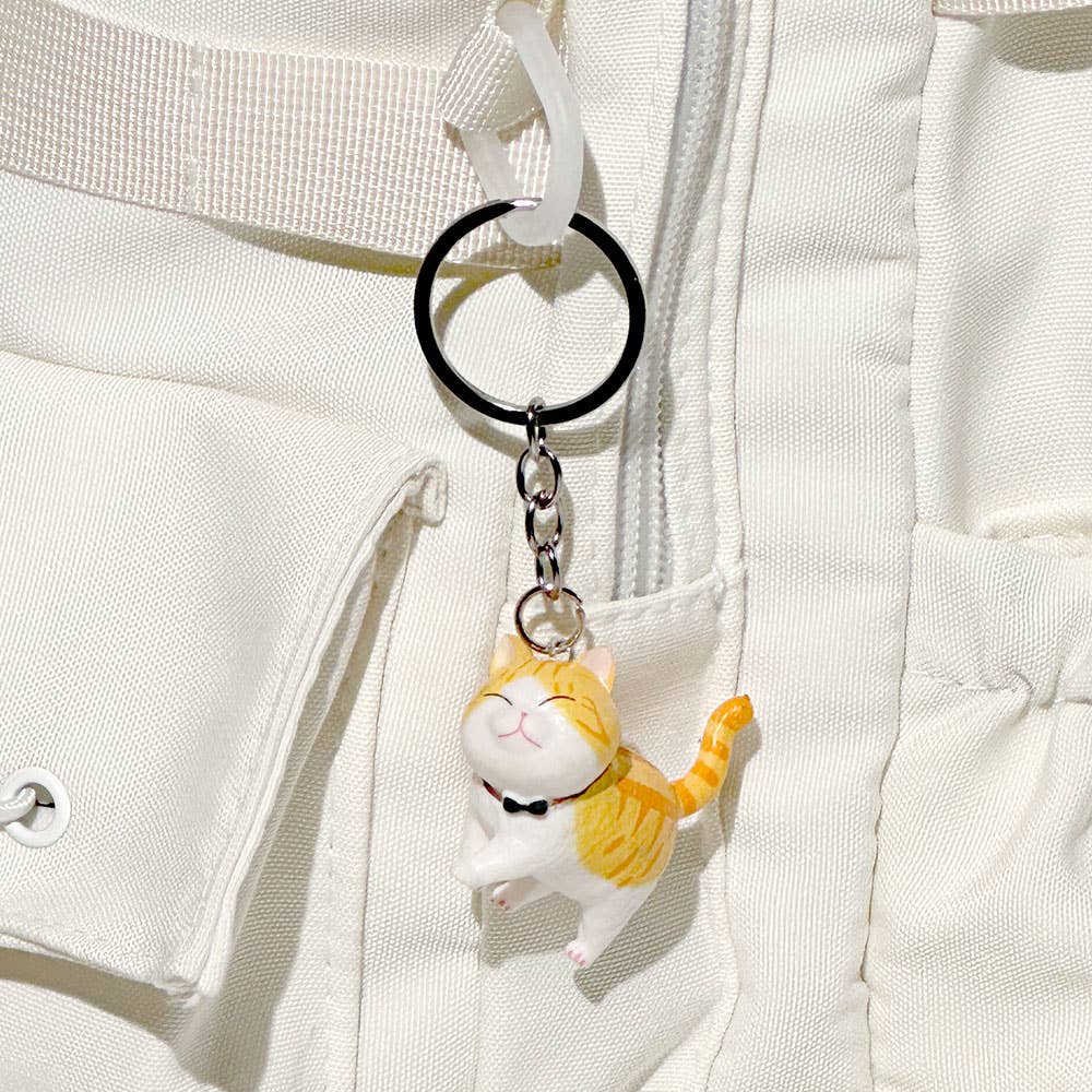 Cat-shaped keychain attached to a white jacket