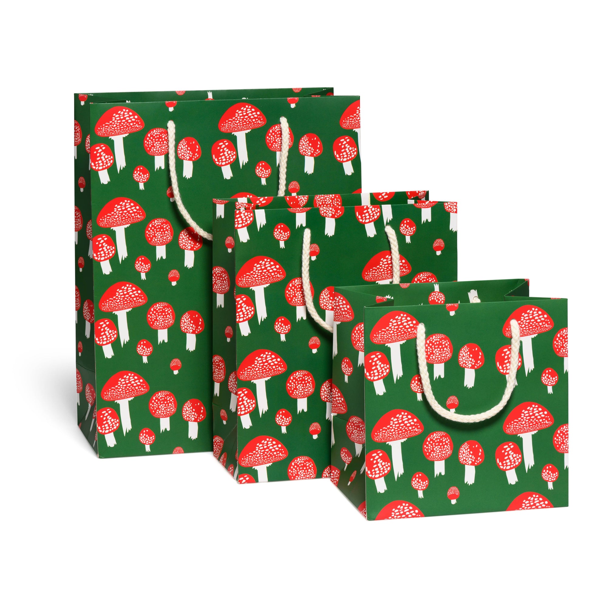 Set of green gift bags with red and white mushroom pattern on a white background