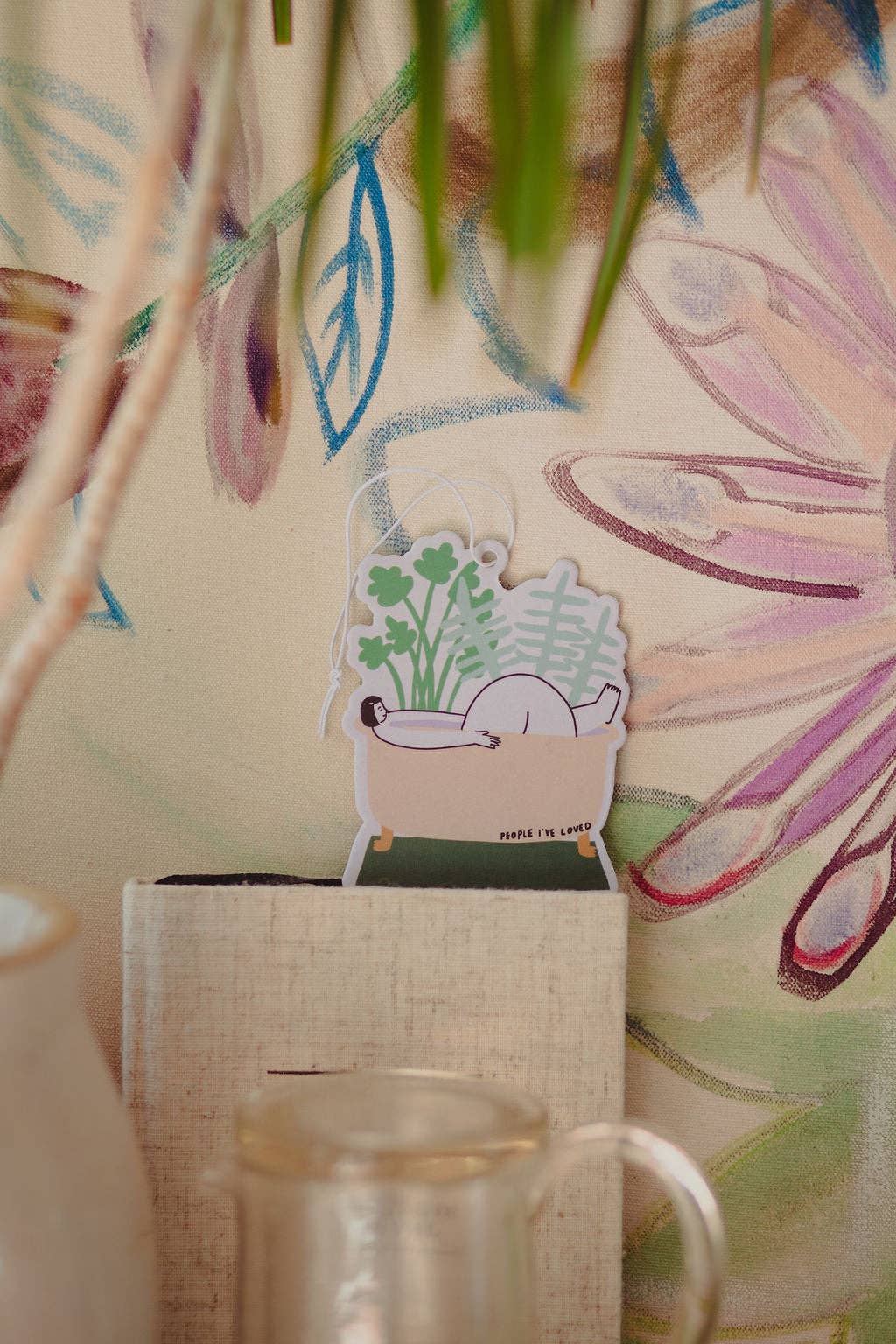 Decorative plant sticker on a textured surface with a colorful abstract painting in the background.