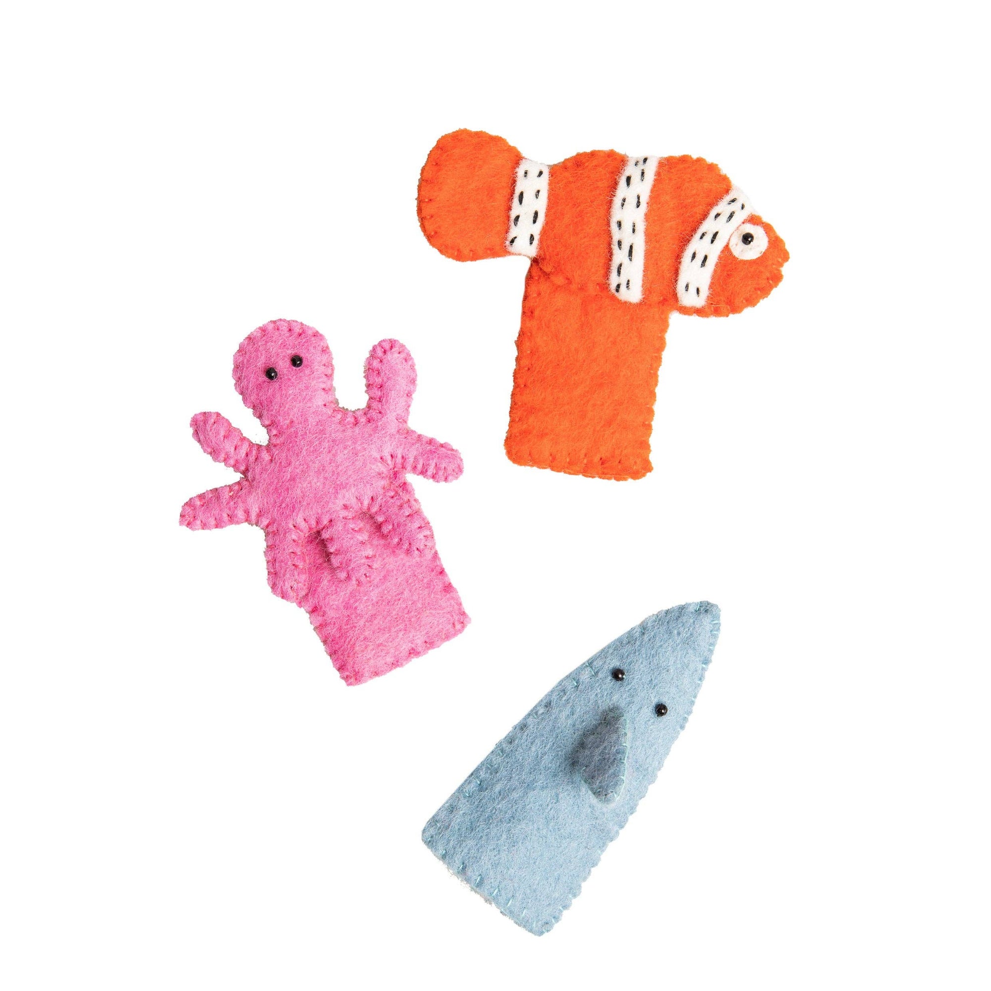 Three plush toys shaped like a pink octopus, orange clownfish, and blue shark on a white background.
