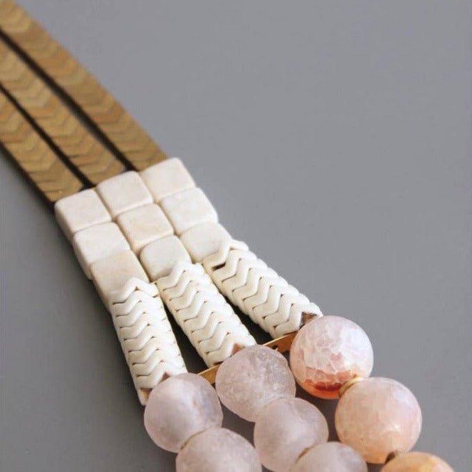Necklace with beaded strands on a gray background