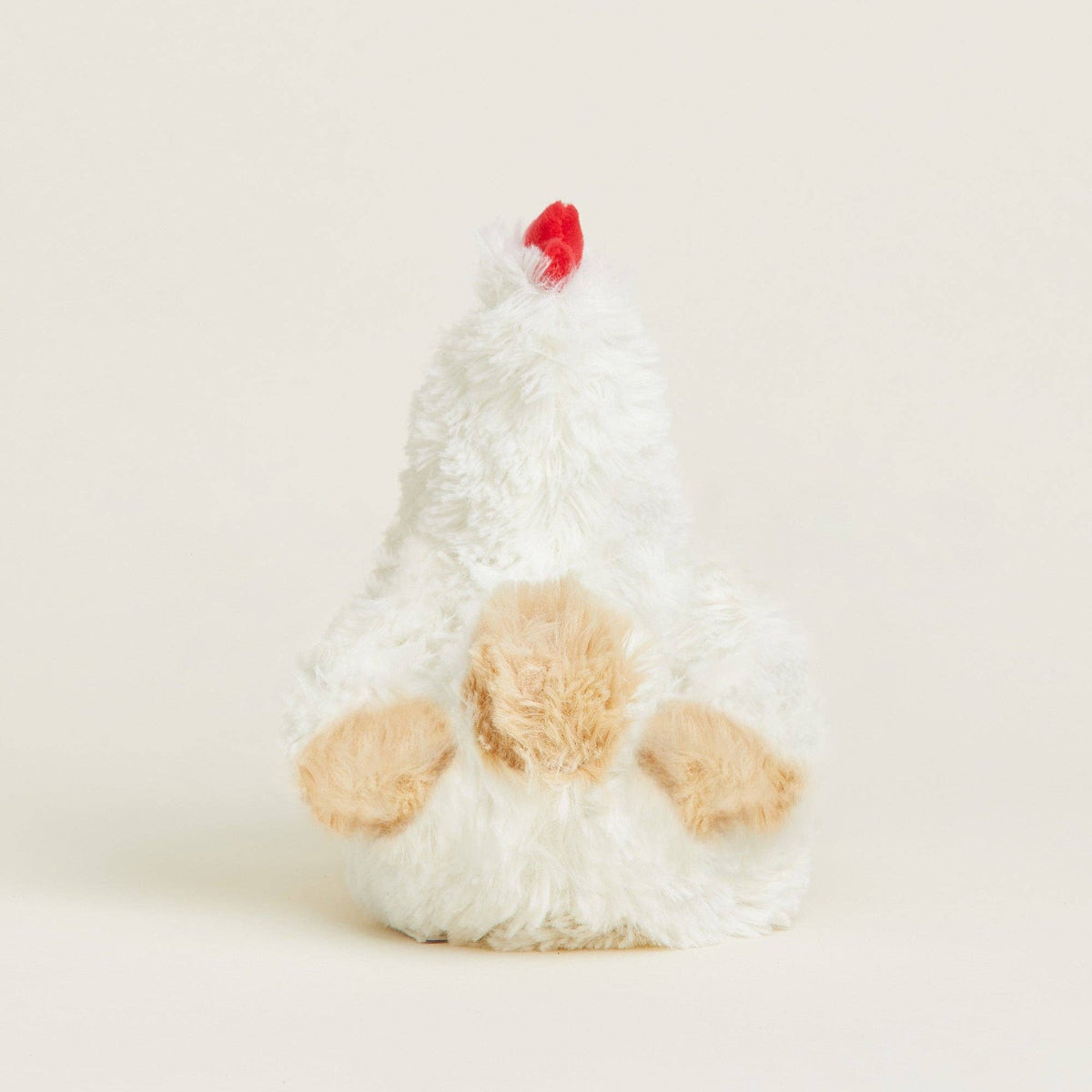 Plush toy resembling a chicken with a red comb on a light background
