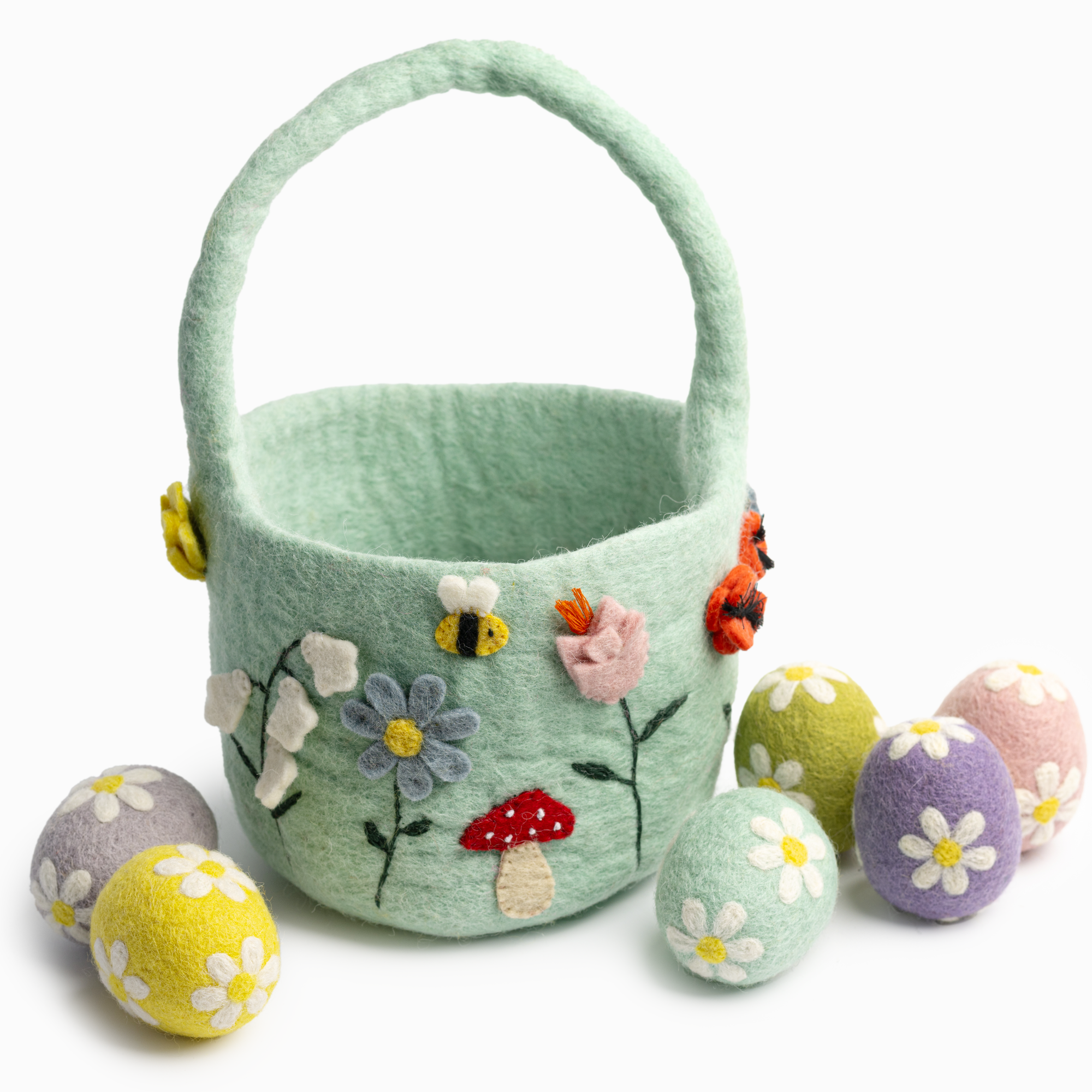 Light green felt Easter basket with floral and mushroom designs, accompanied by colorful felt eggs on a white background.