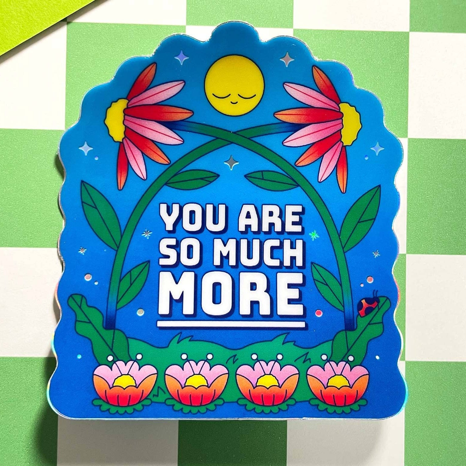 Decorative sign with flowers and text on a green and white checkered background