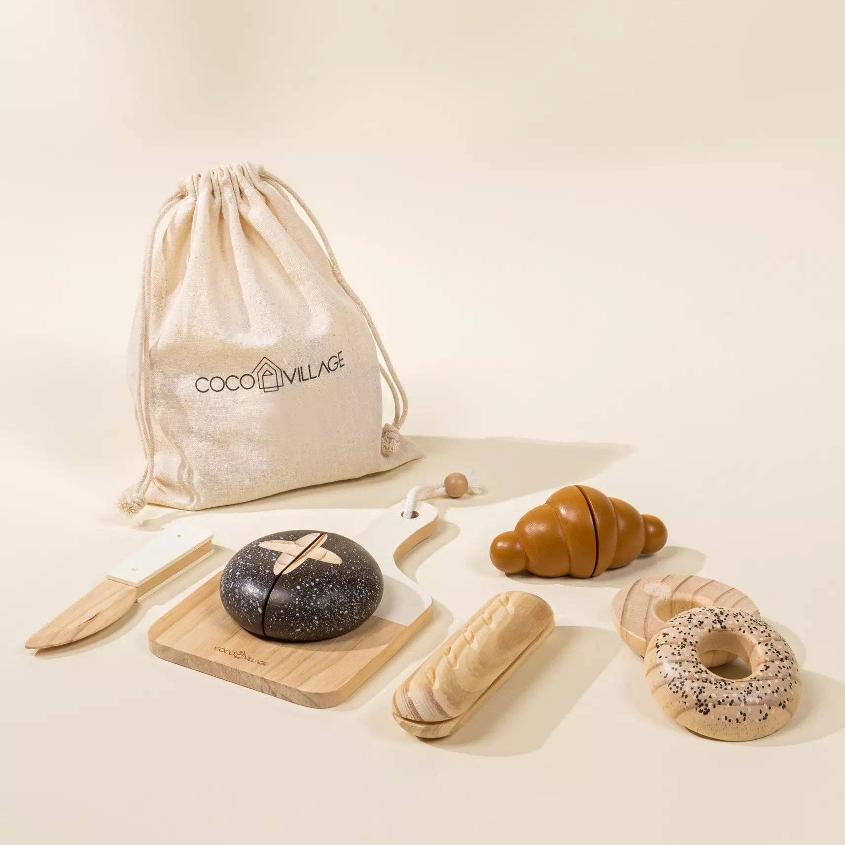 Bakery items including bread and pastries on a light surface with a 'Coco&Lulu' drawstring bag.