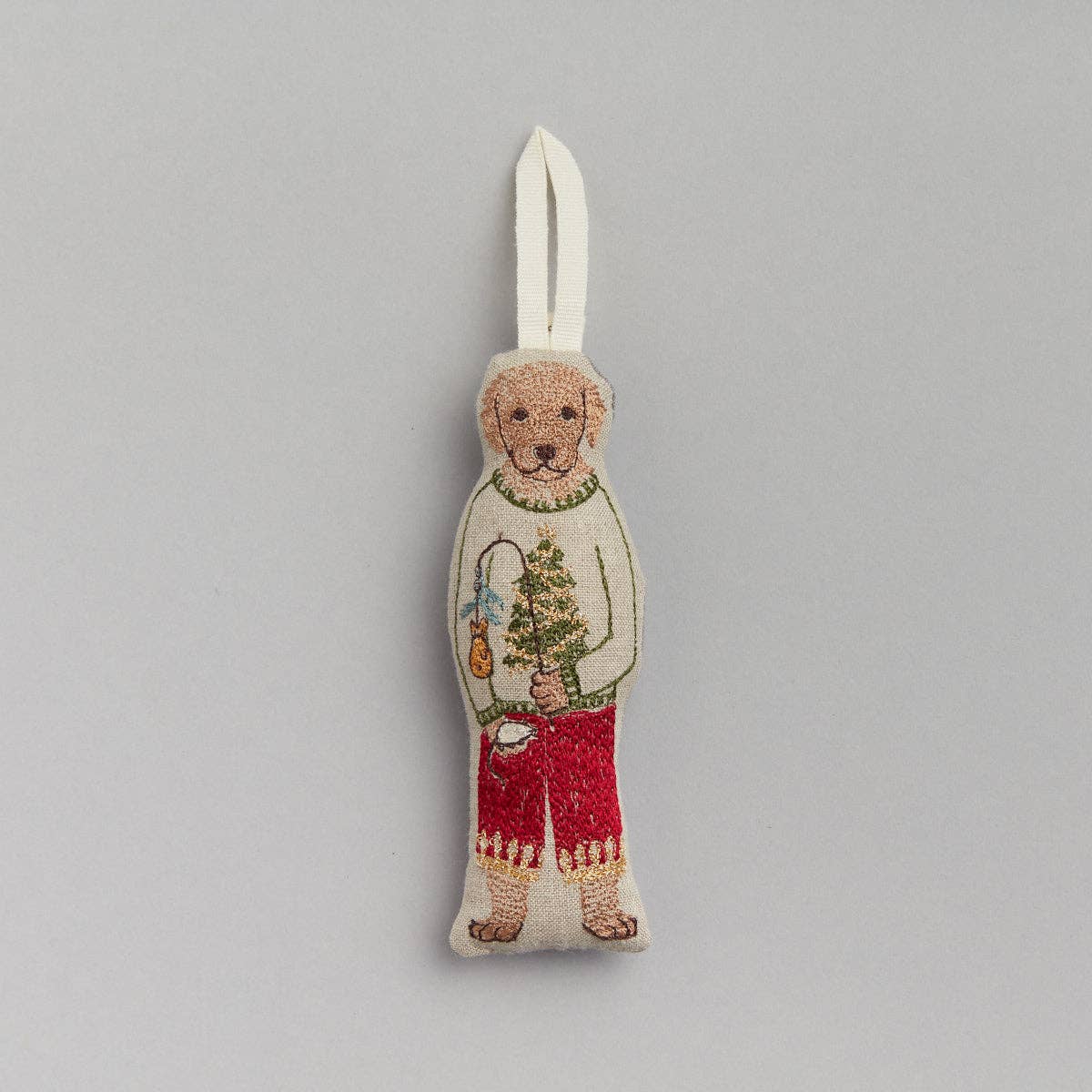 Decorative bear ornament with a sweater and red pants on a gray background
