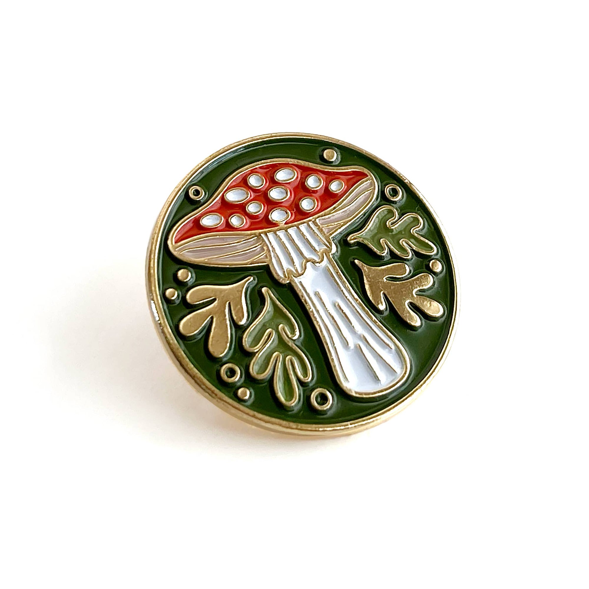 Mushroom-shaped pin with red cap and white stem on a green background